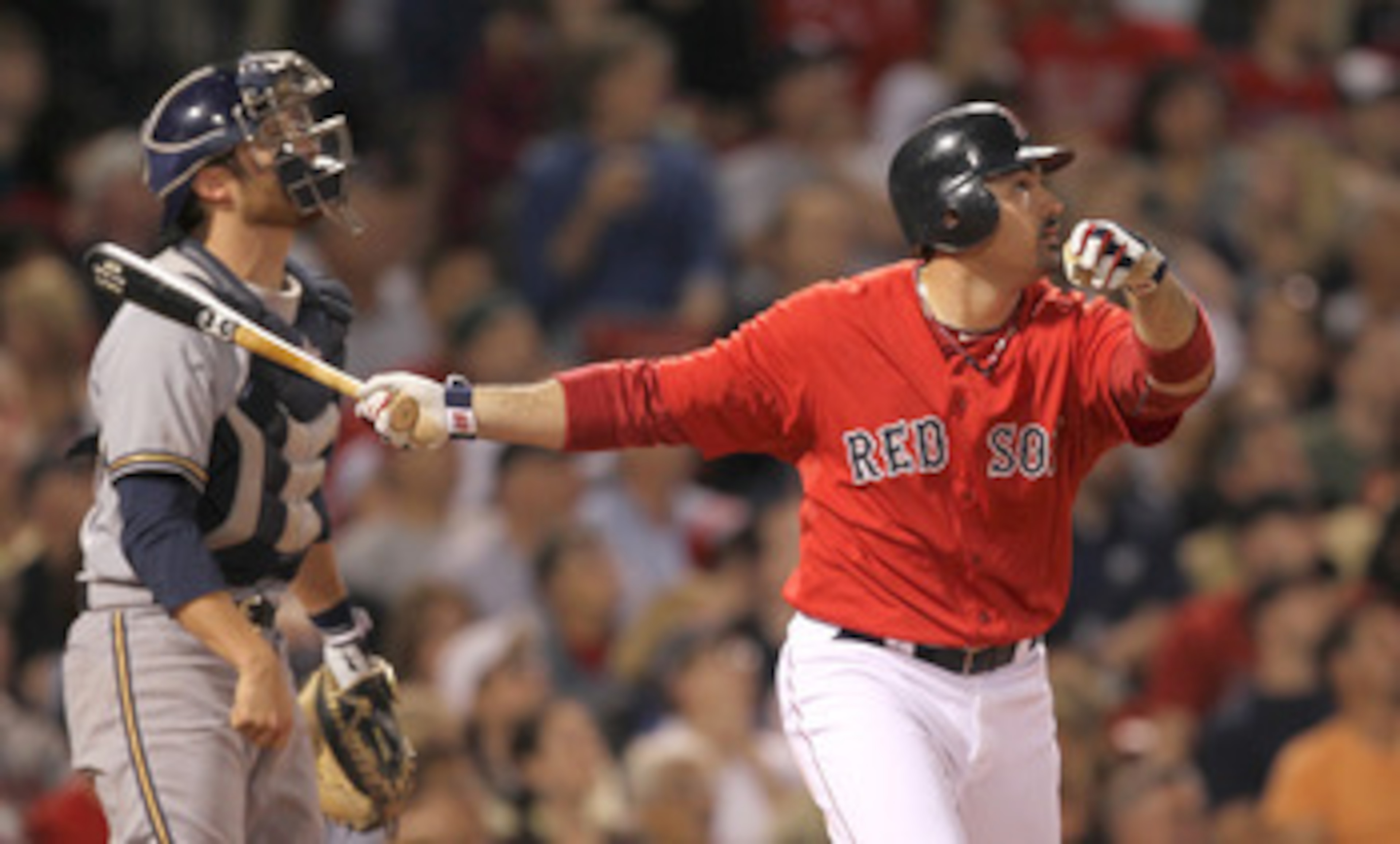 BOSTON, MA  - JUNE 17:  Adrian Gonzalez #28 of the Boston Red Sox connects for a home run as catcher Jonathan Lucroy #20 of the Milwaukee Brewers looks on at Fenway Park on June 17, 2011 in Boston, Massachusetts.  (Photo by Jim Rogash/Getty Images)