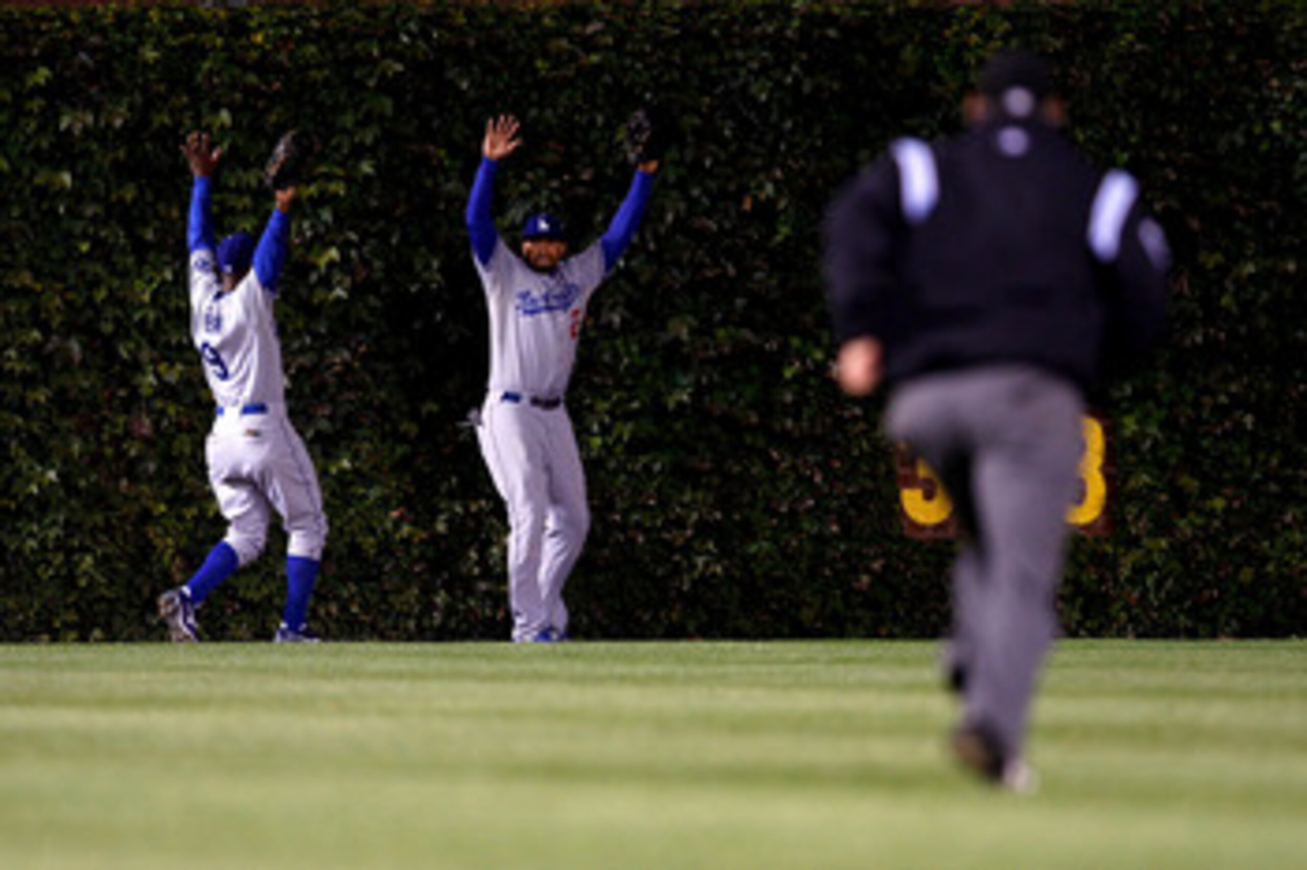 CHICAGO - OCTOBER 02:  (L-R) Juan Pierre #9 and Matt Kemp #27 of the Los Angeles Dodgers raise their arms towards the umpire as they lost the ball in the ivy on a ground rule double hit by Derrek Lee #25 of the Chicago Cubs in Game Two of the NLDS during 