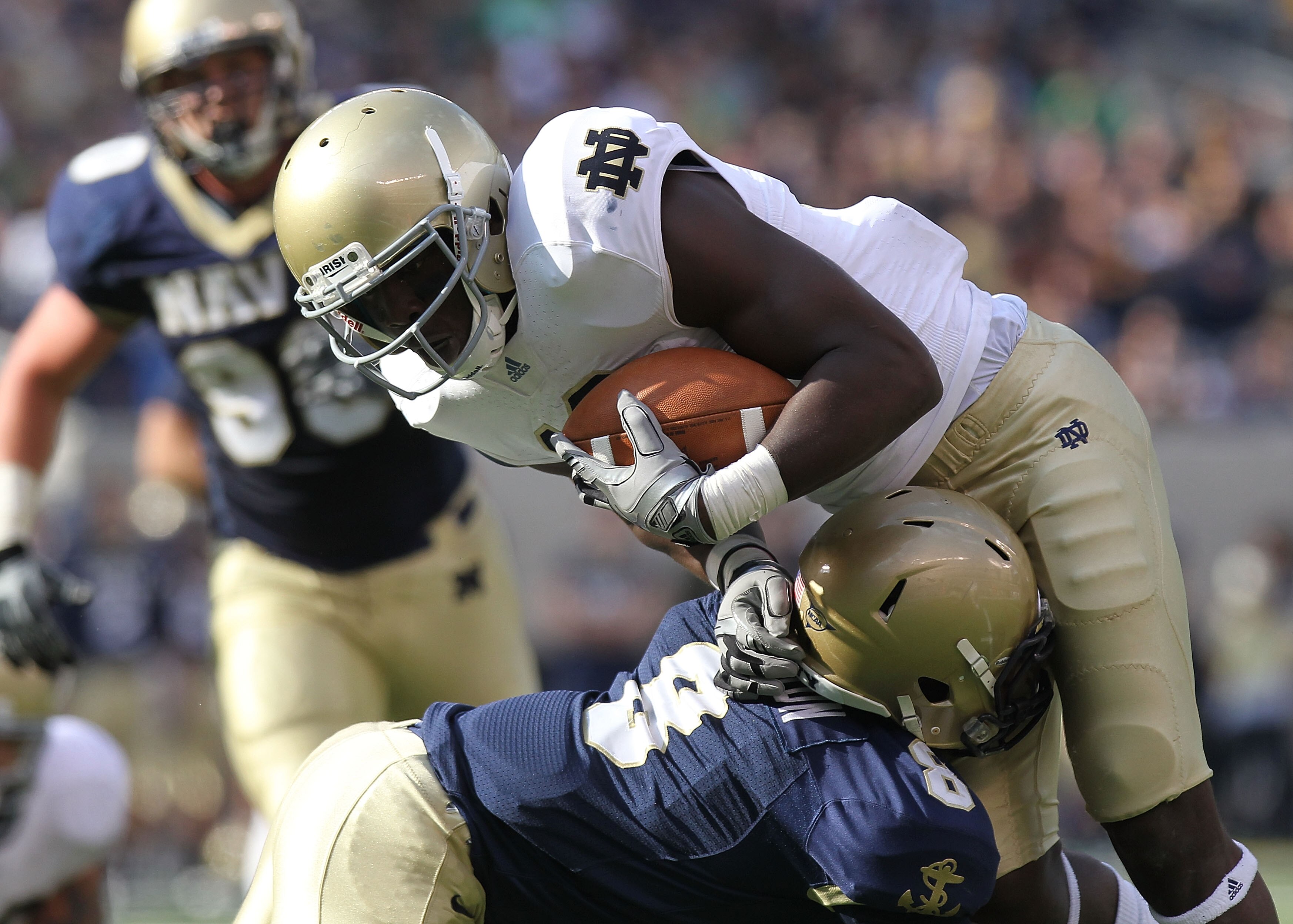 EAST RUTHERFORD, NJ - OCTOBER 23: Duval Kamara #18 of the Notre Dame Fighting Irish is tackled by Wyatt Middleton #8 of the Navy Midshipmen at New Meadowlands Stadium on October 23, 2010 in East Rutherford, New Jersey.  (Photo by Nick Laham/Getty Images)