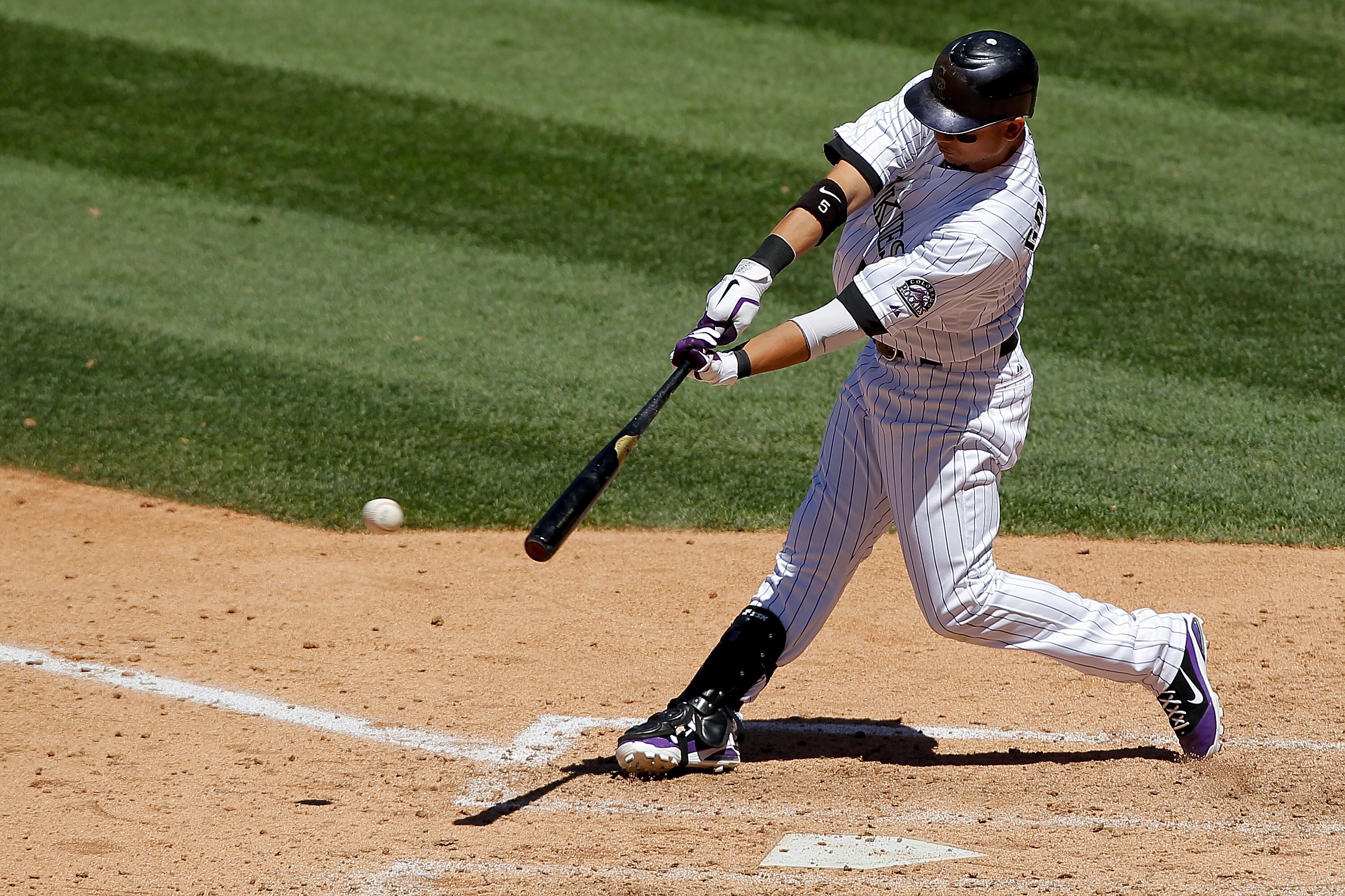 DENVER, CO - JUNE 15: Carlos Gonzalez #5 of the Colorado Rockies singles to center field scoring catcher Jose Morales #26 of the Colorado Rockies in the fifth inning at Coors Field on June 15, 2011 in Denver, Colorado. The Rockies defeated the Padres 6-3.
