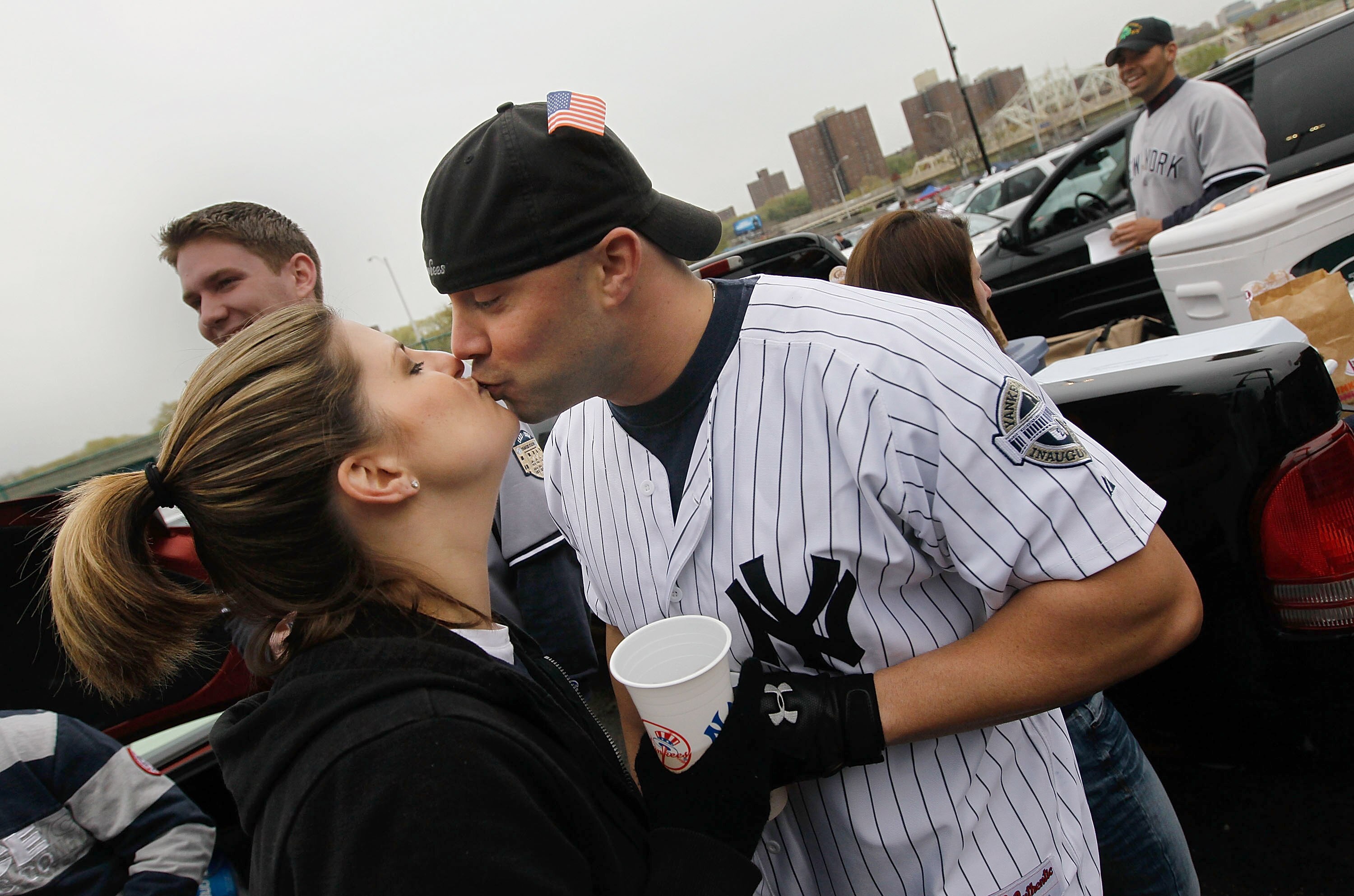 NEW YORK - APRIL 13: Matt Dicembri of Valley Cottage, New York (R) kisses his wife Jaime Dicembri while the couple were tailgating with other New York Yankees fans in the parking lot of Yankee Stadium April 13, 2010 in the Bronx borough of New York City.