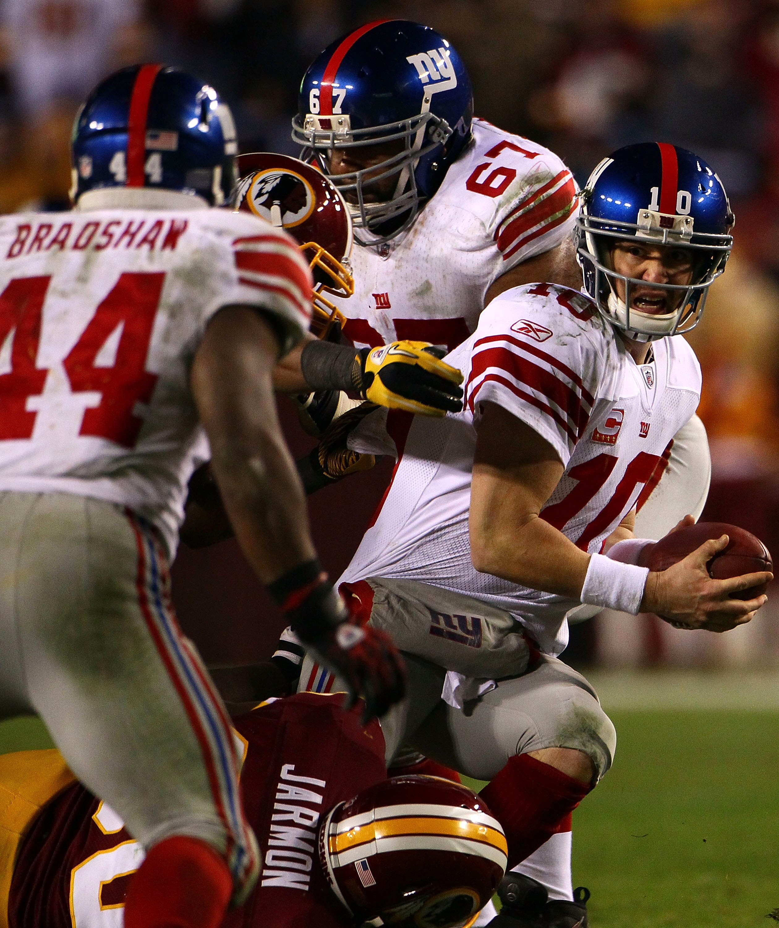 LANDOVER, MD - JANUARY 02:  Quarterback Eli Manning #10 of the New York Giants looks to Ahmad Bradshaw to lateral the ball while being pressured by the Washington Redskins defense during their game at FedEx Field on January 2, 2011 in Landover, Maryland.