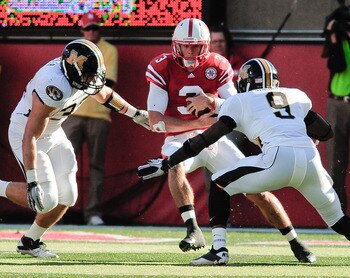 LINCOLN, NE - OCTOBER 30: Quarterback Taylor Martinez #3 of the Nebraska Cornhuskers tries to slip between Missouri Tiger defenders during first half action of their game at Memorial Stadium on October 30, 2010 in Lincoln, Nebraska. Nebraska Defeated Miss