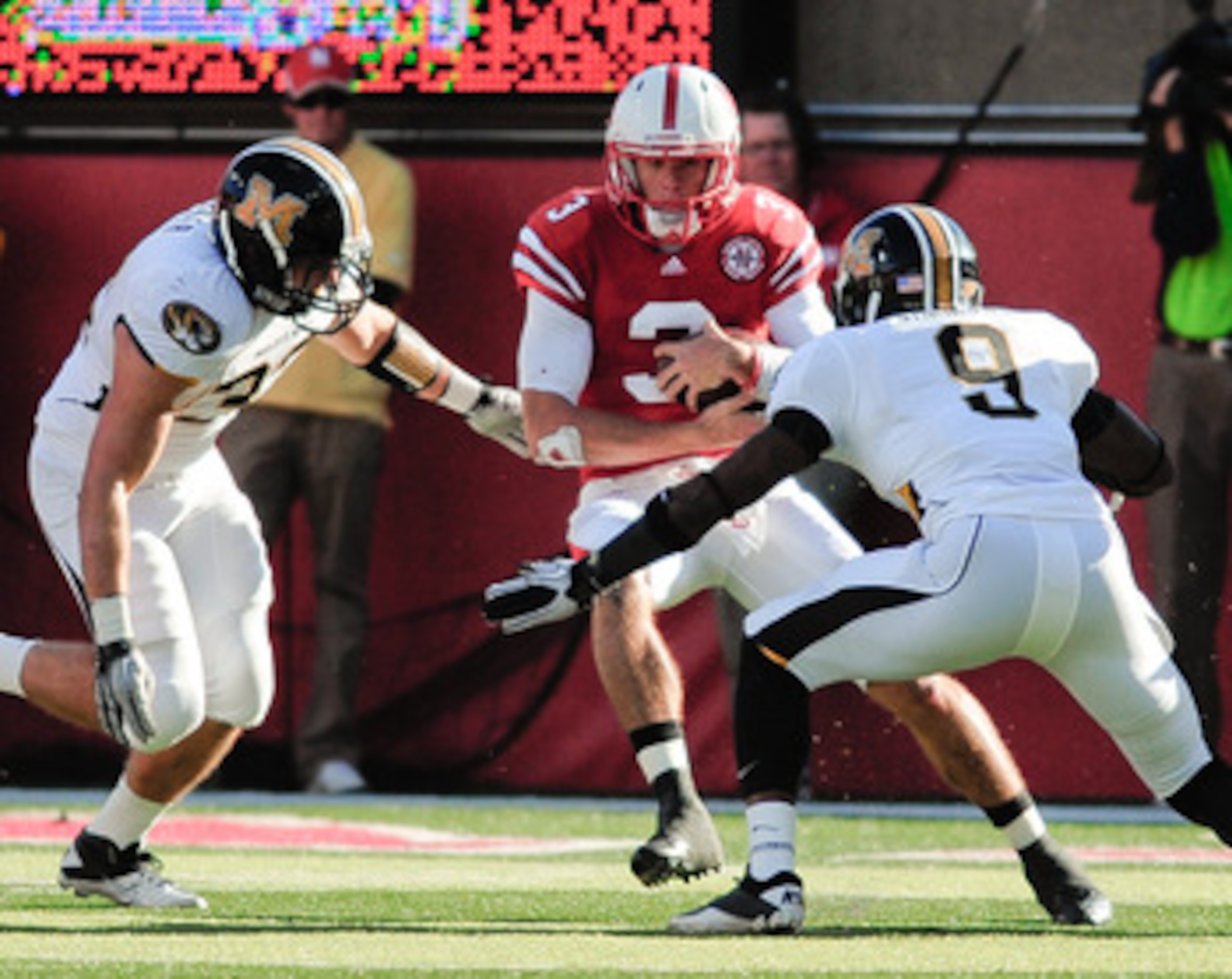 LINCOLN, NE - OCTOBER 30: Quarterback Taylor Martinez #3 of the Nebraska Cornhuskers tries to slip between Missouri Tiger defenders during first half action of their game at Memorial Stadium on October 30, 2010 in Lincoln, Nebraska. Nebraska Defeated Miss LINCOLN, NE - OCTOBER 30: Quarterback Taylor Martinez #3 of the Nebraska Cornhuskers tries to slip between Missouri Tiger defenders during first half action of their game at Memorial Stadium on October 30, 2010 in Lincoln, Nebraska. Nebraska Defeated Miss
