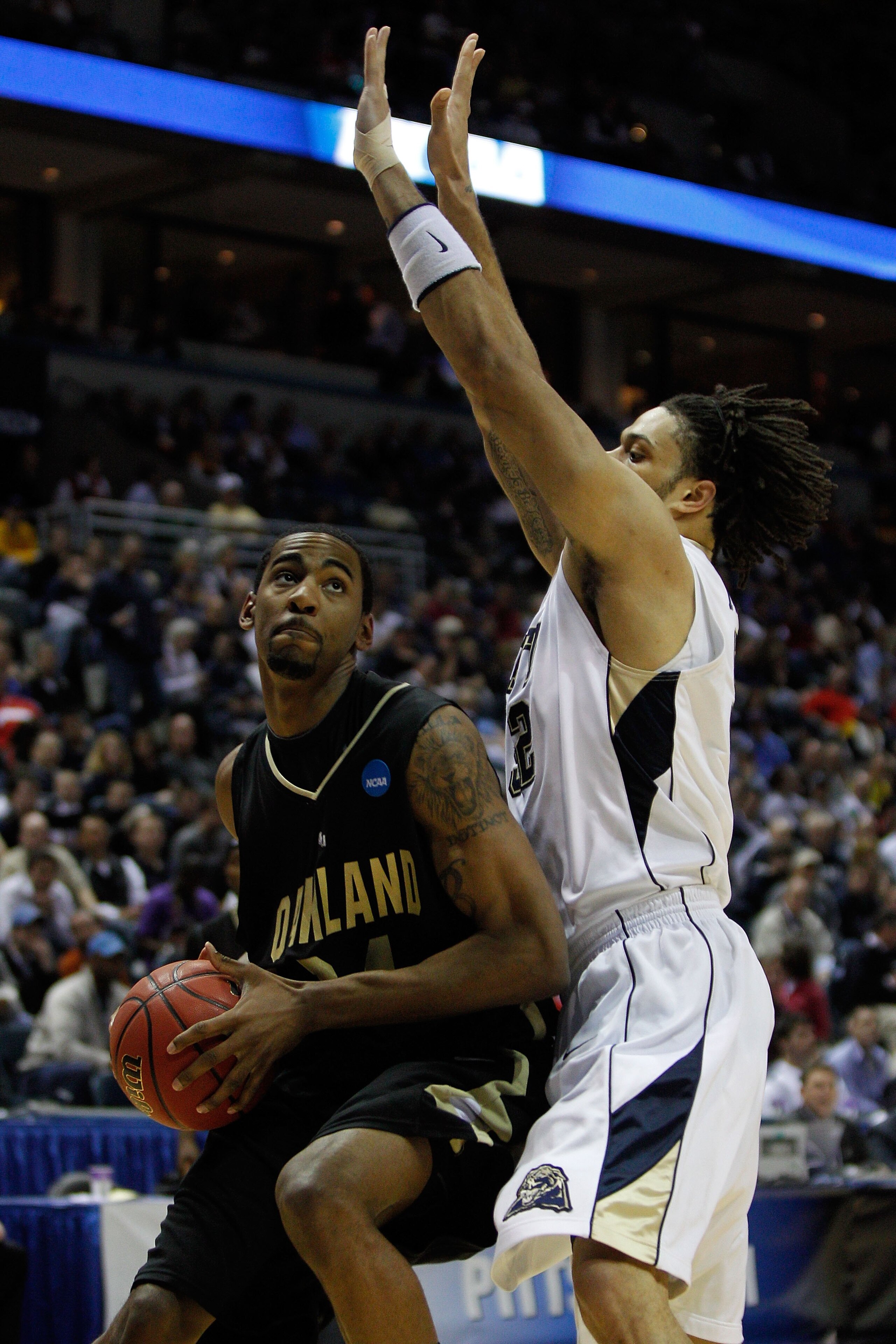 MILWAUKEE - MARCH 19: Keith Benson #34 of the Oakland Golden Grizzlies looks to shoot over Gary McGhee #52 of the of the Pittsburgh Panthers in the first half during the first round of the 2010 NCAA men's basketball tournament at the Bradley Center on Ma MILWAUKEE - MARCH 19: Keith Benson #34 of the Oakland Golden Grizzlies looks to shoot over Gary McGhee #52 of the of the Pittsburgh Panthers in the first half during the first round of the 2010 NCAA men's basketball tournament at the Bradley Center on Ma