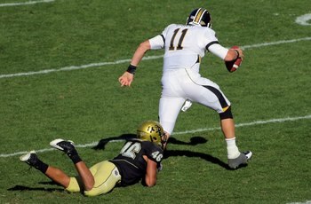 BOULDER, CO - OCTOBER 31:  Quarterback Blaine Gabbert #11 of the Missouri Tigers scrambles and tries to break the tackle of Anthony Perkins #46 of the Colorado Buffaloes at Folsom Field on October 31, 2009 in Boulder, Colorado. Missouri defeated Colorado