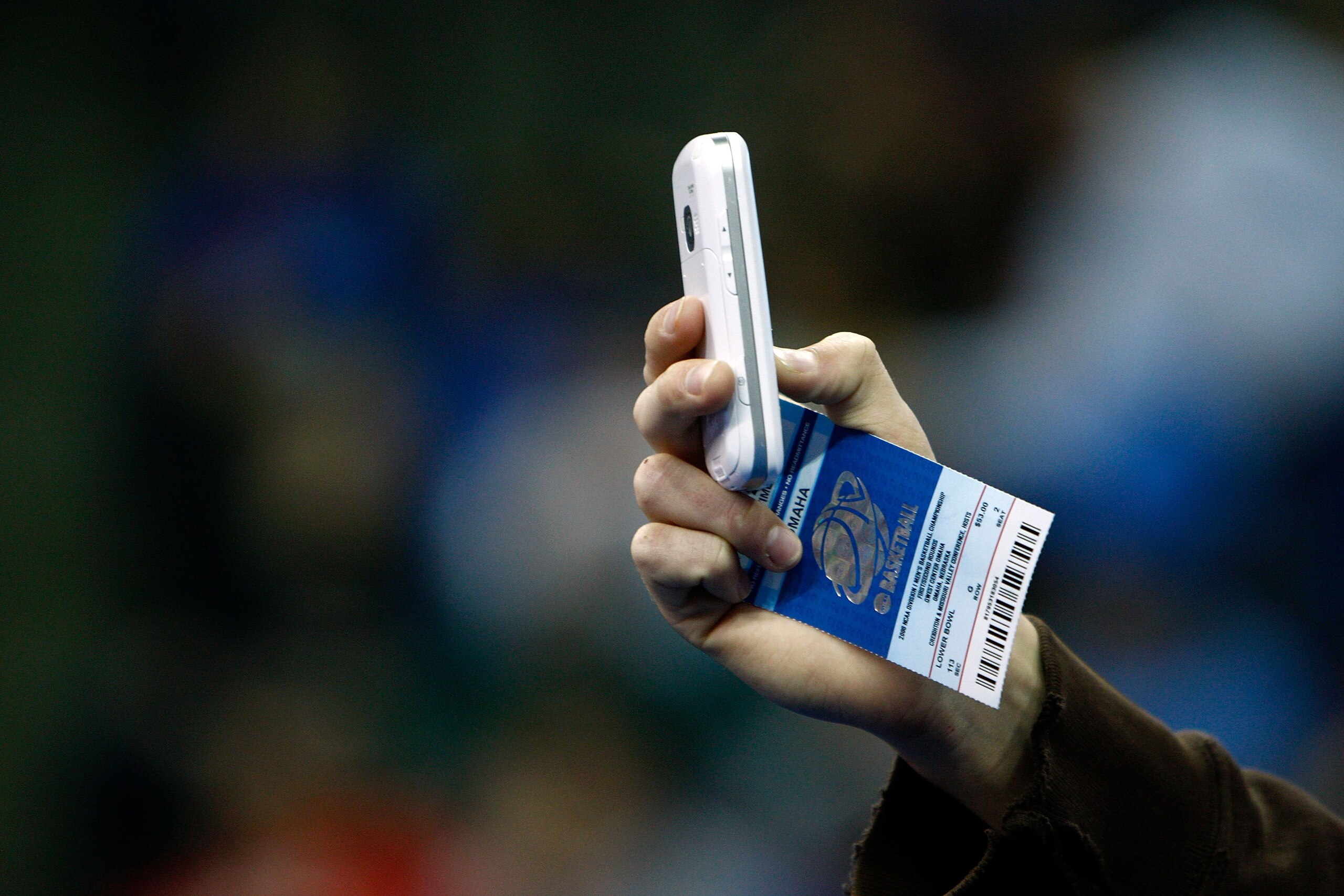 OMAHA, NE - MARCH 20: A detail of a fan taking a photo with a camera phone while holding his ticket as the USC Trojans play against the Kansas State Wildcats during the Midwest Region first round of the 2008 NCAA Men's Basketball Tournament on March 20, OMAHA, NE - MARCH 20: A detail of a fan taking a photo with a camera phone while holding his ticket as the USC Trojans play against the Kansas State Wildcats during the Midwest Region first round of the 2008 NCAA Men's Basketball Tournament on March 20,