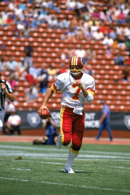 LOS ANGELES -1983:  Joe Theismann #7 of the Washington Redskins moves as he looks to pass during a 1983 NFL season game against the Los Angeles Raiders at Los Angeles Coliseum in Los Angeles, California. (Photo by: Tony Duffy/Getty Images)