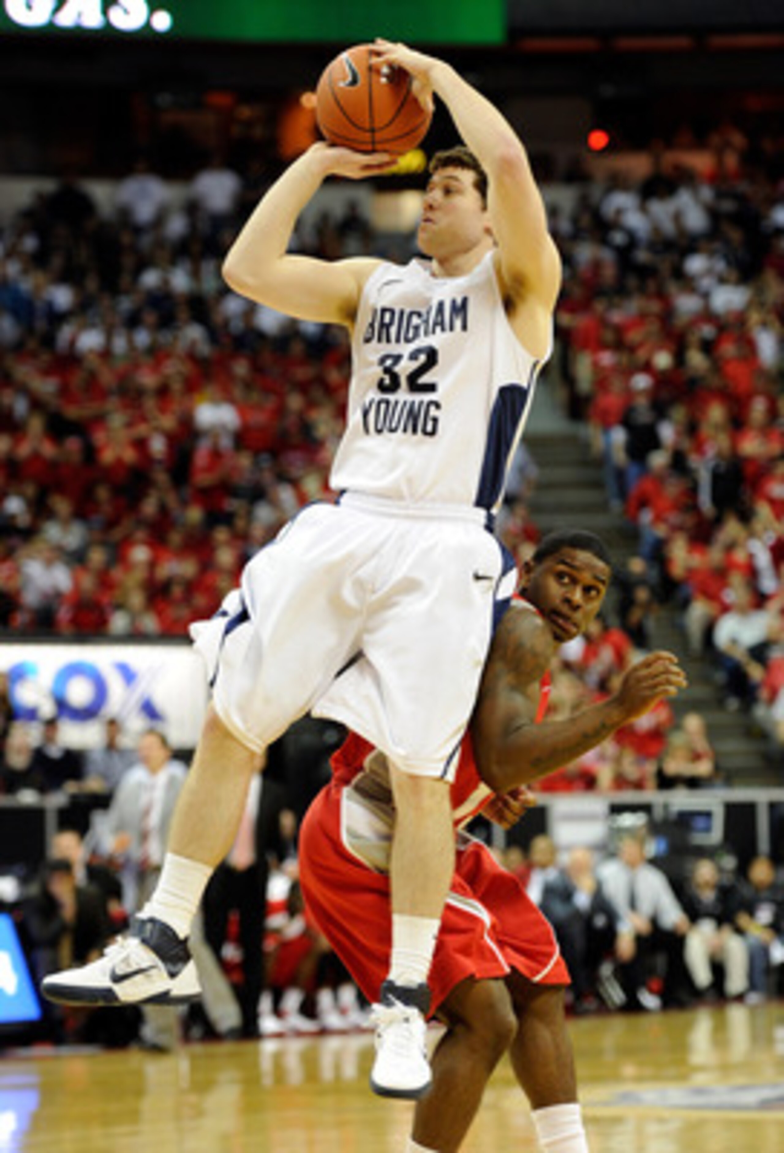 LAS VEGAS, NV - MARCH 11:  Jimmer Fredette #32 of the Brigham Young University Cougars shoots over Jamal Fenton #13 of the New Mexico Lobos during a semifinal game of the Conoco Mountain West Conference Basketball tournament at the Thomas & Mack Center Ma