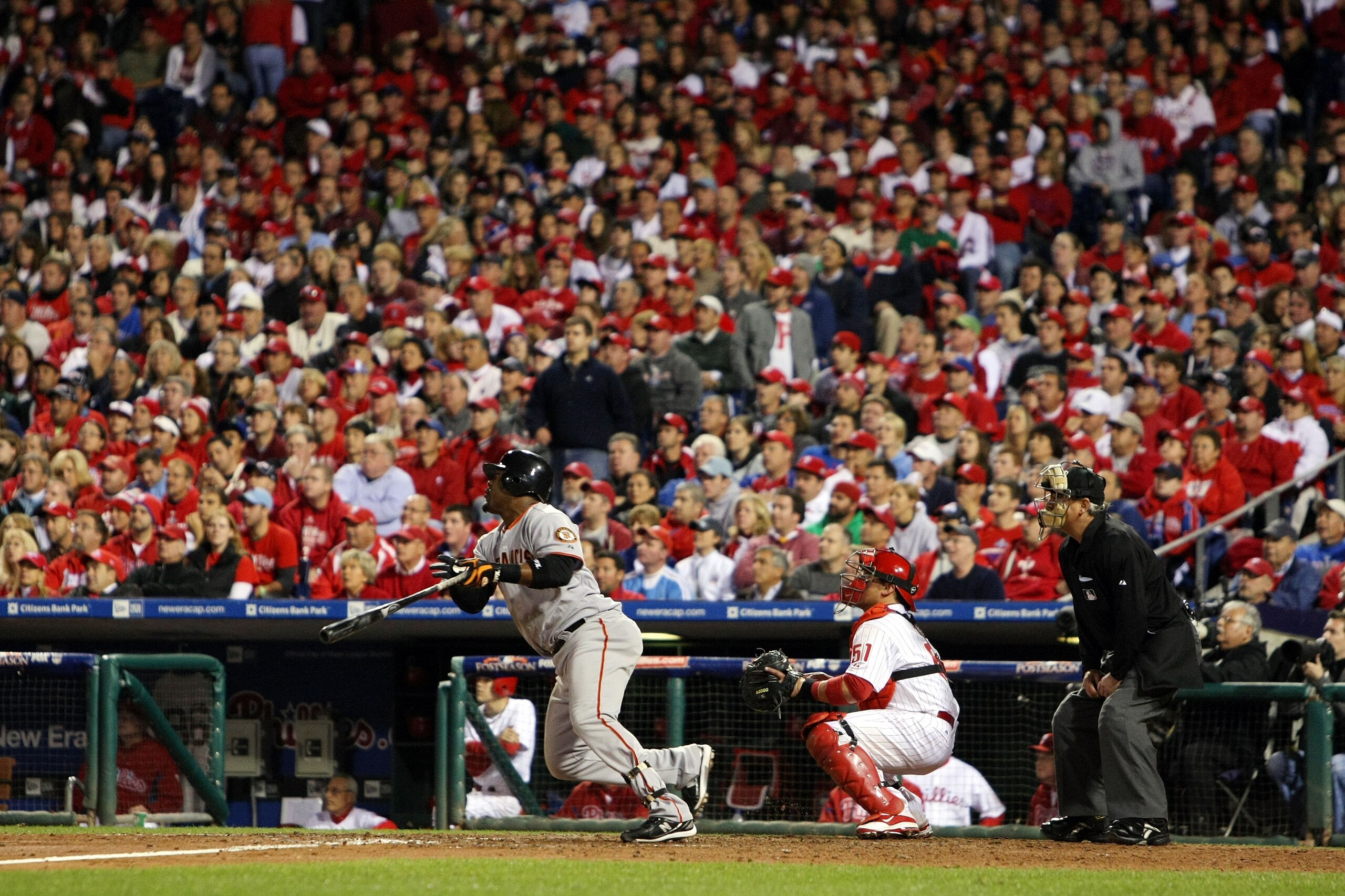 PHILADELPHIA - OCTOBER 23:  Juan Uribe #5 of the San Francisco Giants hits a solo home run to take a 3-2 lead in the eigth inning as Carlos Ruiz #51 of the Philadelphia Phillies looks on in Game Six of the NLCS during the 2010 MLB Playoffs at Citizens Ban