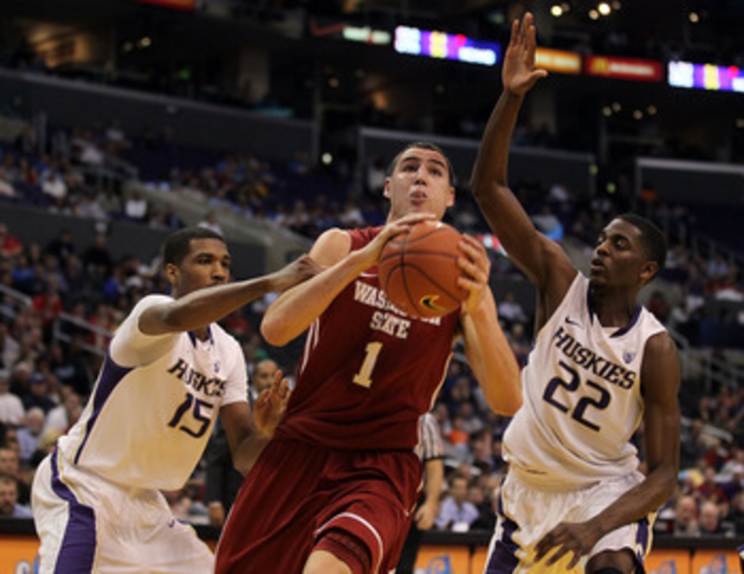 LOS ANGELES, CA - MARCH 10:  Klay Thompson #1 of the Washington State Cougars drives between Scott Suggs #15 and Justin Holiday #22 of the Washington Huskies in the first half in the quarterfinals of the 2011 Pacific Life Pac-10 Men's Basketball Tournamen