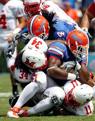 GAINESVILLE, FL - SEPTEMBER 04:  Linebacker Jonathan Bostic #52 of the Florida Gators is tackled by Thomas Merriweather #34 of the Miami University RedHawks following a interceptionat Ben Hill Griffin Stadium on September 4, 2010 in Gainesville, Florida.