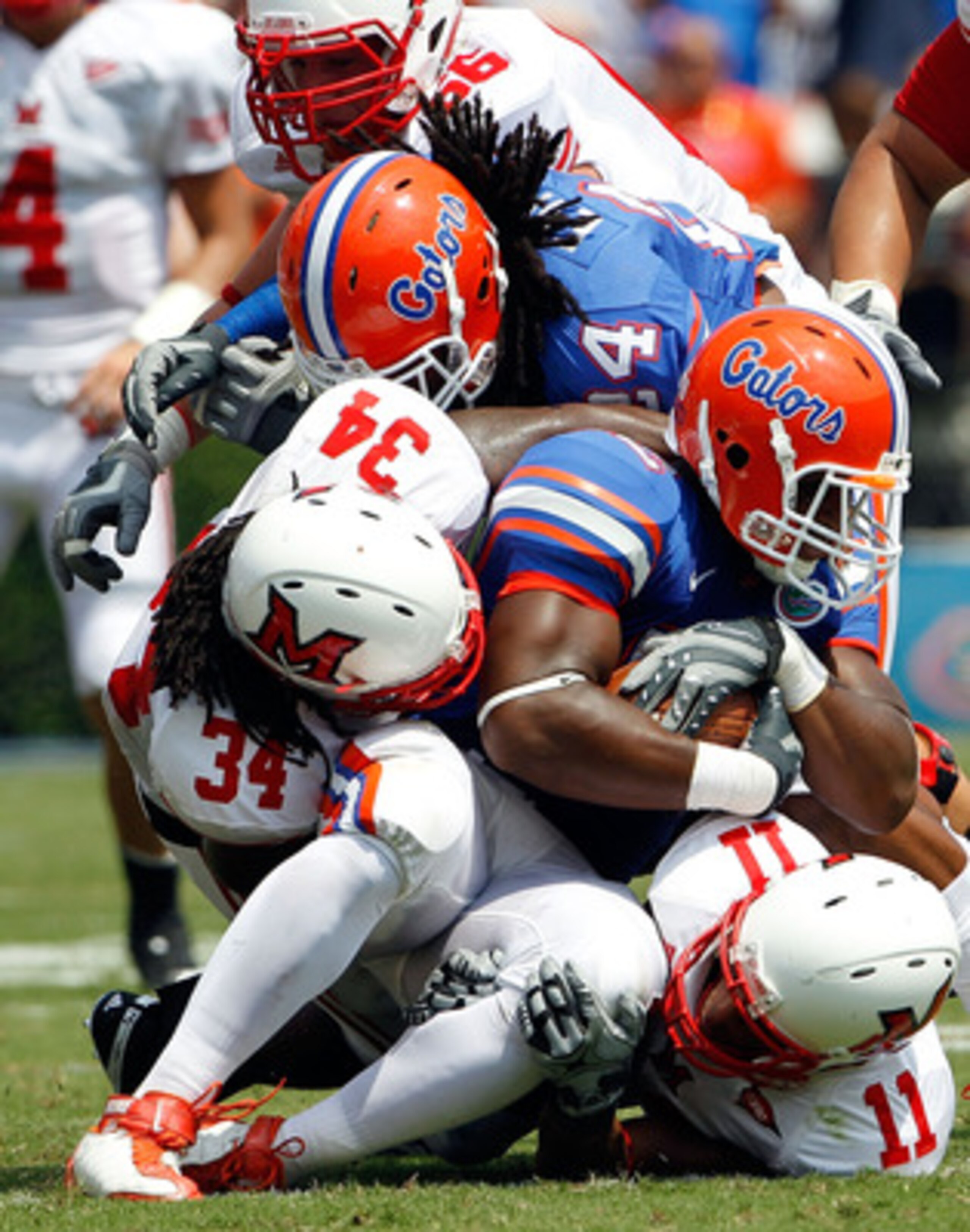 GAINESVILLE, FL - SEPTEMBER 04:  Linebacker Jonathan Bostic #52 of the Florida Gators is tackled by Thomas Merriweather #34 of the Miami University RedHawks following a interceptionat Ben Hill Griffin Stadium on September 4, 2010 in Gainesville, Florida.