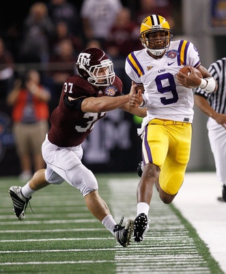 ARLINGTON, TX - JANUARY 07:  Jordan Jefferson #9 of the Louisiana State University Tigers is pushed out of bounds by Michael Hodges #37 of the Texas A&M Aggies during the AT&T Cotton Bowl at Cowboys Stadium on January 7, 2011 in Arlington, Texas.  (Photo