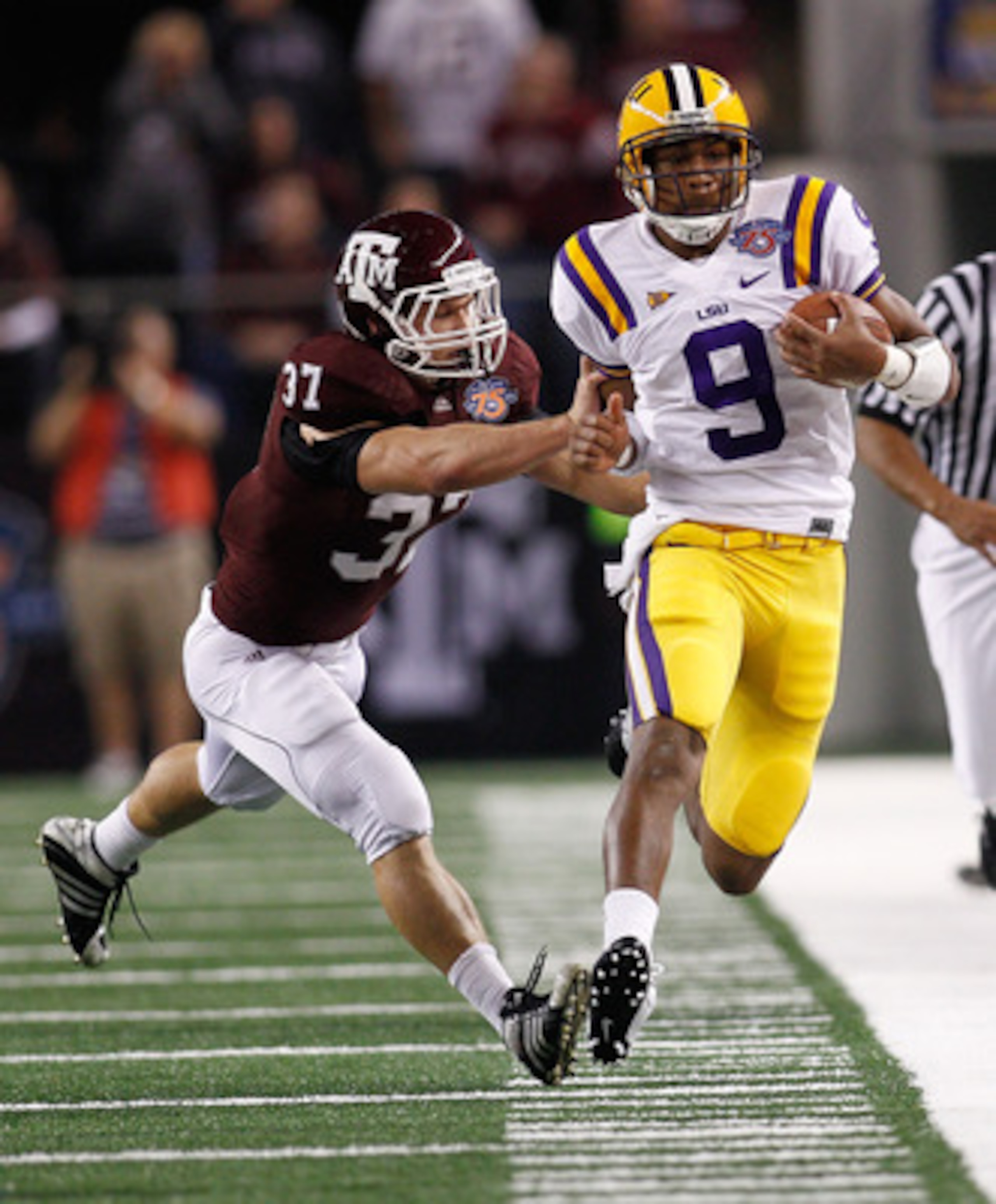 ARLINGTON, TX - JANUARY 07:  Jordan Jefferson #9 of the Louisiana State University Tigers is pushed out of bounds by Michael Hodges #37 of the Texas A&M Aggies during the AT&T Cotton Bowl at Cowboys Stadium on January 7, 2011 in Arlington, Texas.  (Photo