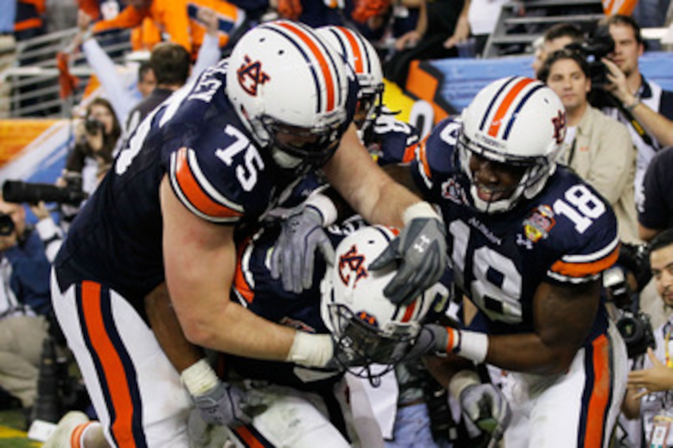 GLENDALE, AZ - JANUARY 10:  (C) Michael Dyer #5 of the Auburn Tigers celebrates with teammates Brandon Mosley #75 and Kodi Burns #18 after he ran the ball for 16-yards and is called down at the one-yardline with 10 seconds remaining in the fourth quarter