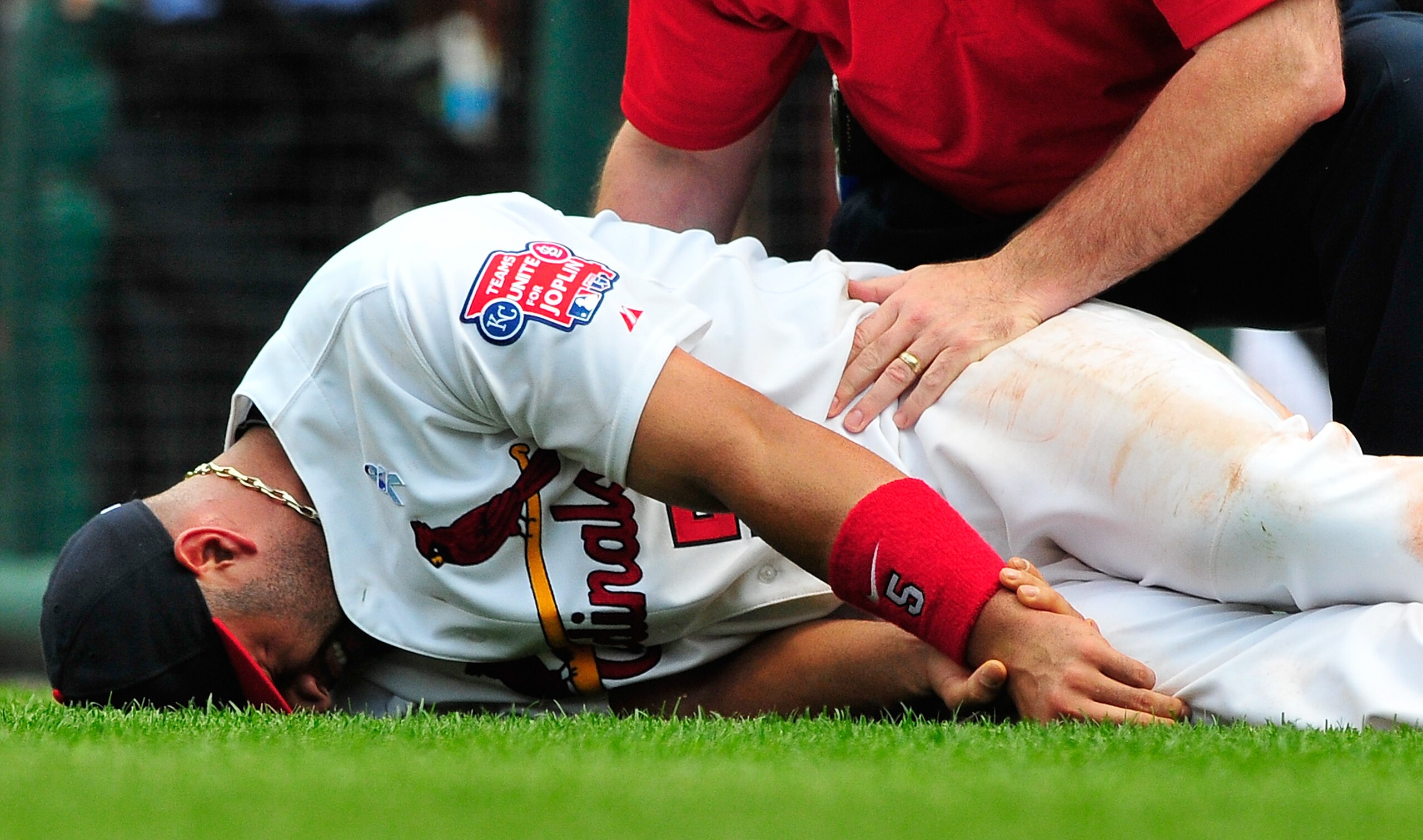 ST. LOUIS, MO - JUNE 19: Albert Pujols #5 of the St. Louis Cardinals holds his wrist after a collision with Wilson Betemit #24 of the Kansas City Royals at Busch Stadium on June 19, 2011 in St. Louis, Missouri.  (Photo by Jeff Curry/Getty Images)