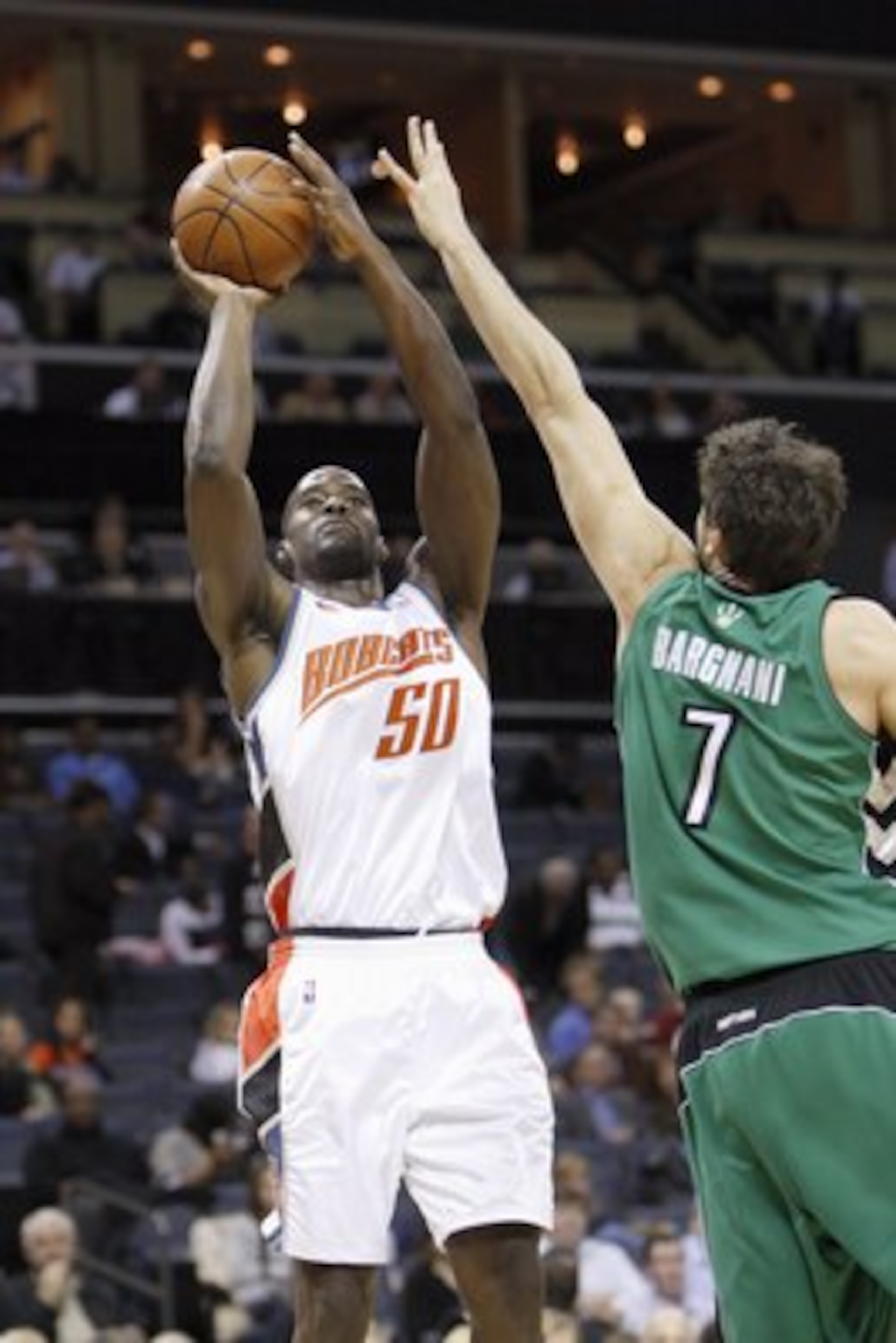 CHARLOTTE, NC - MARCH 16:  Emeka Okafor #50 of the Charlotte Bobcats takes a shot against Andrea Bargnani #7 of the Toronto Raptors during their game at Time Warner Cable Arena on March 16, 2009 in Charlotte, North Carolina.  NOTE TO USER: User expressly