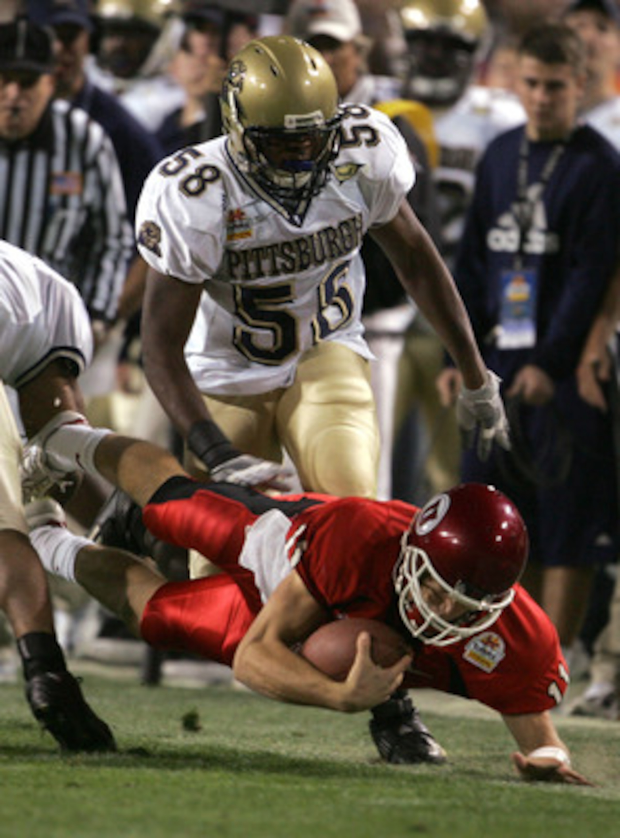 TEMPE, AZ - JANUARY 1:  Quarterback Alex Smith #11 of Utah is tripped up by Joe Clermond #58 of Pittsburgh in the first quarter of the Tostito's Fiesta Bowl at the Sun Devil Stadium on January 1, 2005 in Tempe, Arizona. (Photo by Jeff Gross/Getty Images).