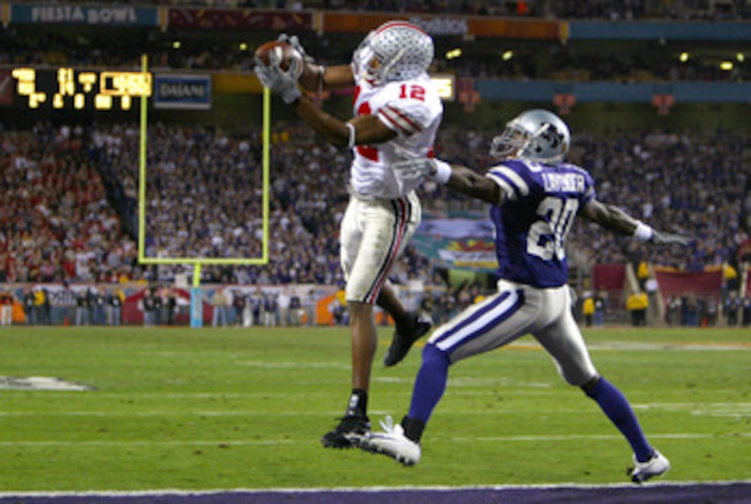 TEMPE, AZ - JANUARY 2:  Michael Jenkins #12 of the Ohio State Buckeyes catches a touchdown pass over the defense of Louis Lavender #20 of the Kansas State Wildcats during the second half of the Fiesta Bowl on January 2, 2004 at the Sun Devil Stadium in Te