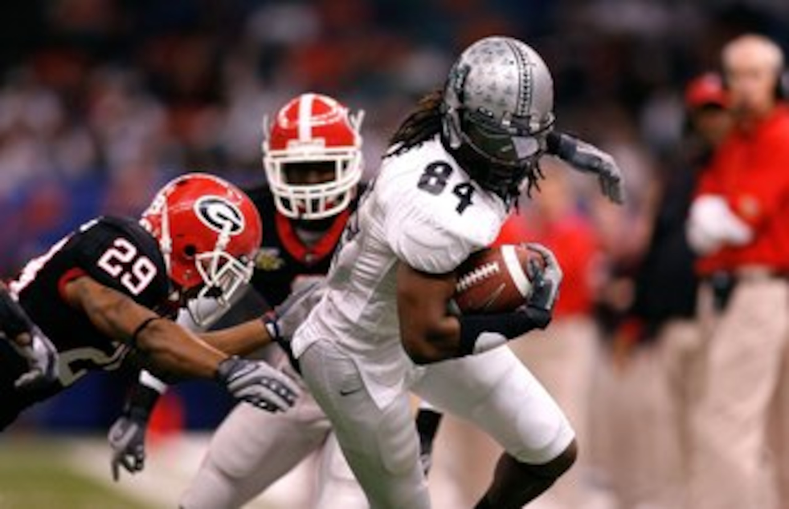 NEW ORLEANS - JANUARY 01:  Jason Rivers #84 of the Hawai'i Warriors runs for yards after the catch against Thomas Flowers #29 of the Georgia Bulldogs during the Allstate Sugar Bowl at the Louisiana Superdome on January 1, 2008 in New Orleans, Louisiana. G