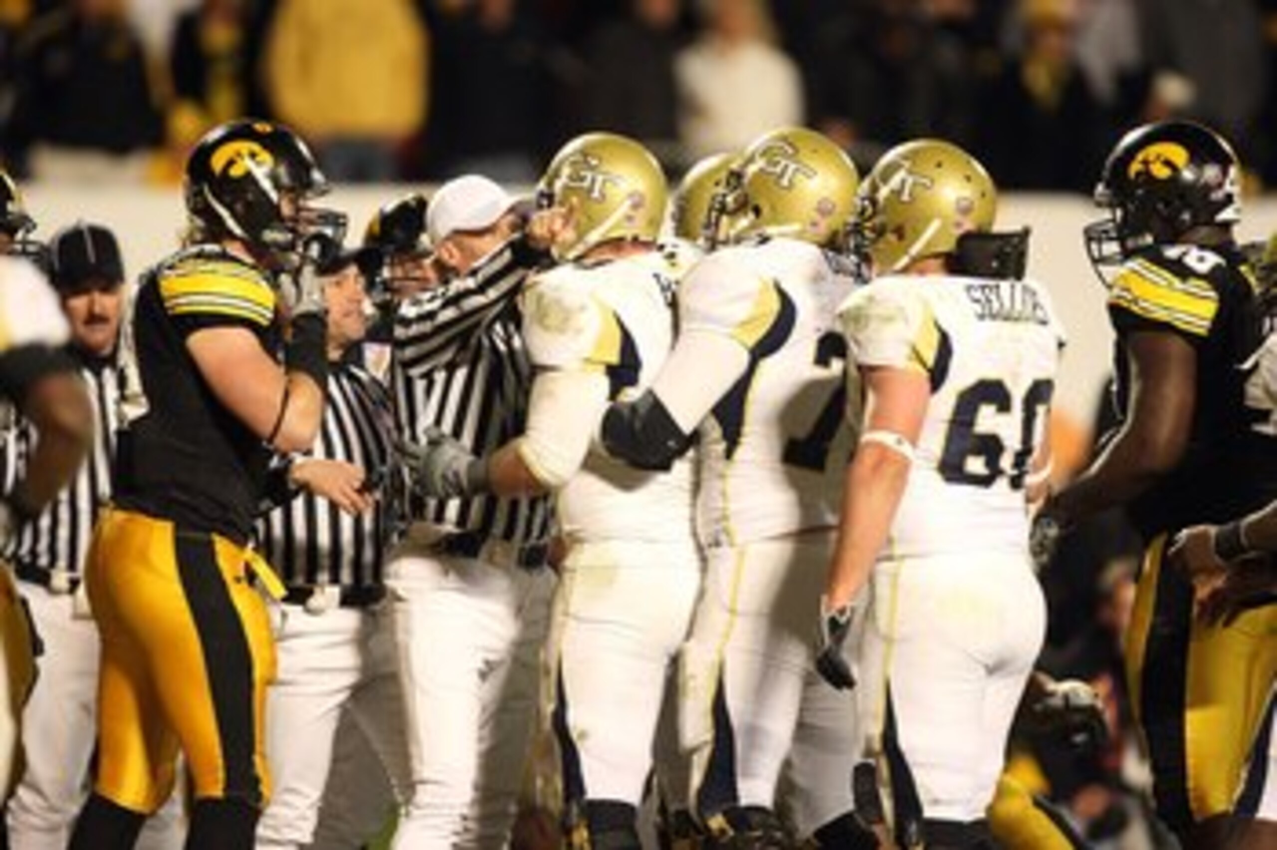 MIAMI GARDENS, FL - JANUARY 05:  Players from the Iowa Hawkeyes and the Georgia Tech Yellow Jackets are seperated by the referee during the FedEx Orange Bowl at Land Shark Stadium on January 5, 2010 in Miami Gardens, Florida.  (Photo by Streeter Lecka/Get