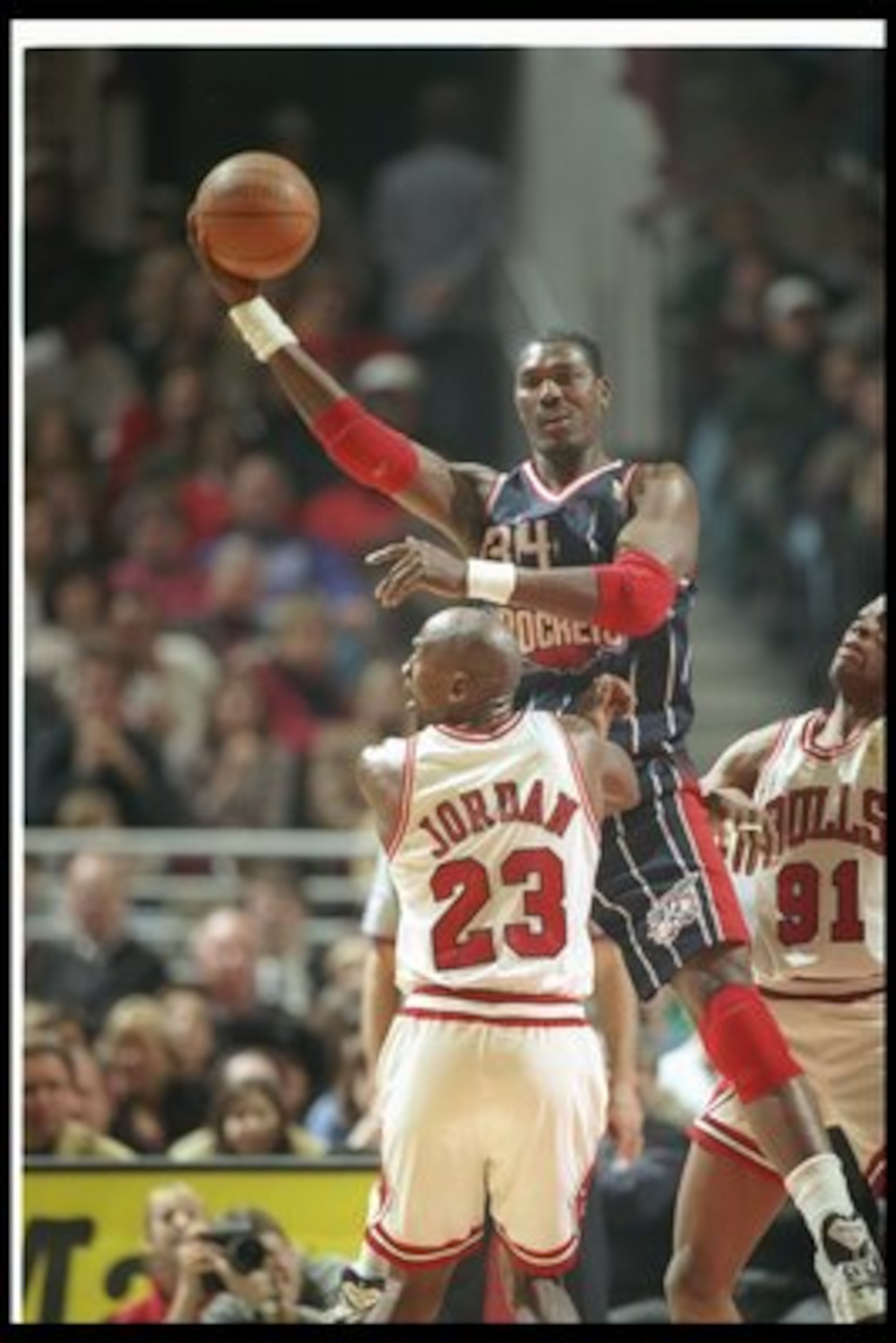 11 Jan 1997:  Center Hakeem Olajuwon of the Houston Rockets leaps for control of the balll over the defense of guard Michael Jordan (center)  and forward Dennis Rodman of the Chicago Bulls during a game at the United Center in Chicago, Illinois.  The Bull