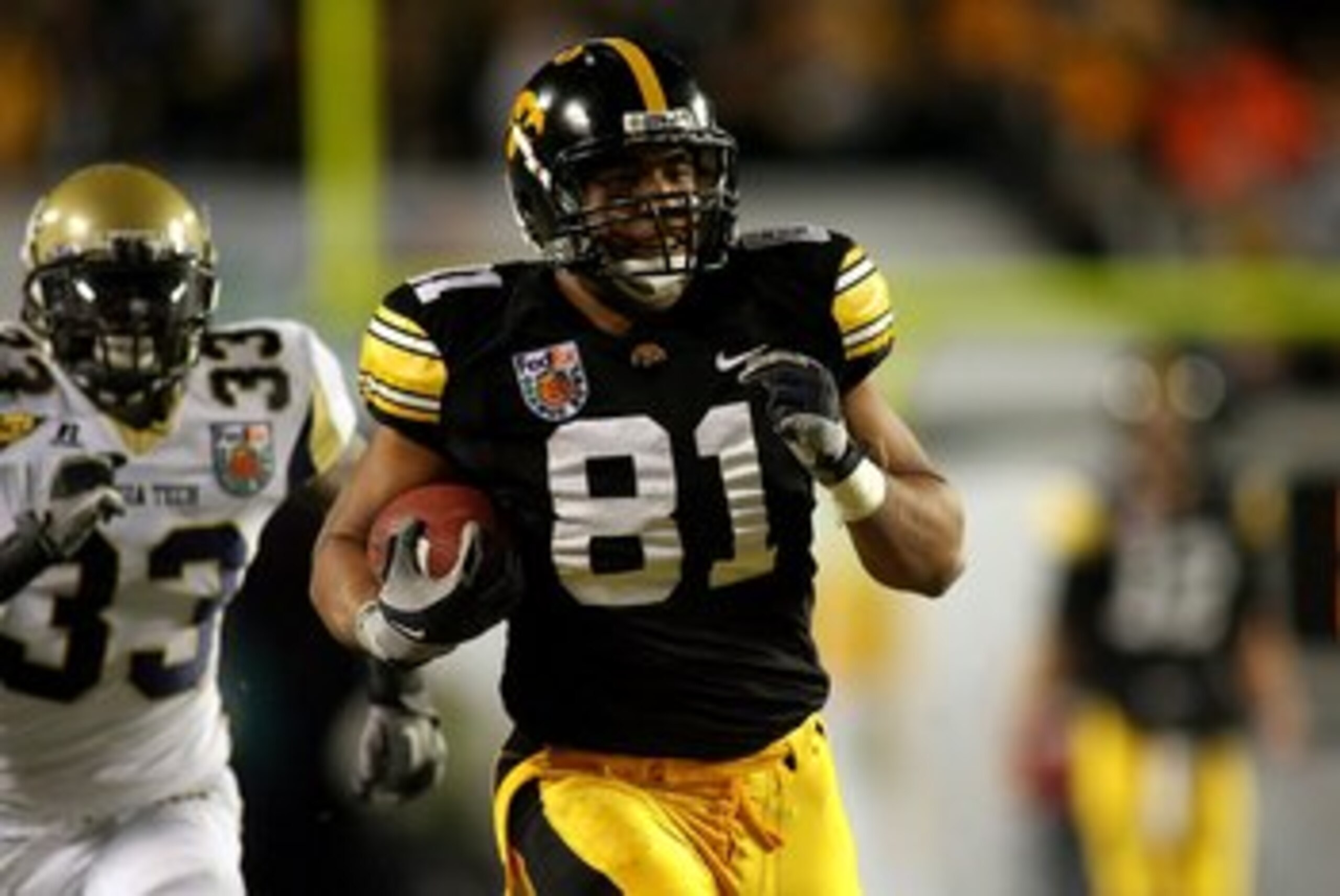 MIAMI GARDENS, FL - JANUARY 05:  Tony Moeaki #81 of the Iowa Hawkeyes runs for yards after the catch on a 54-yard reception in the first quarter against Mario Edwards #33 of the Georgia Tech Yellow Jackets during the FedEx Orange Bowl at Land Shark Stadiu