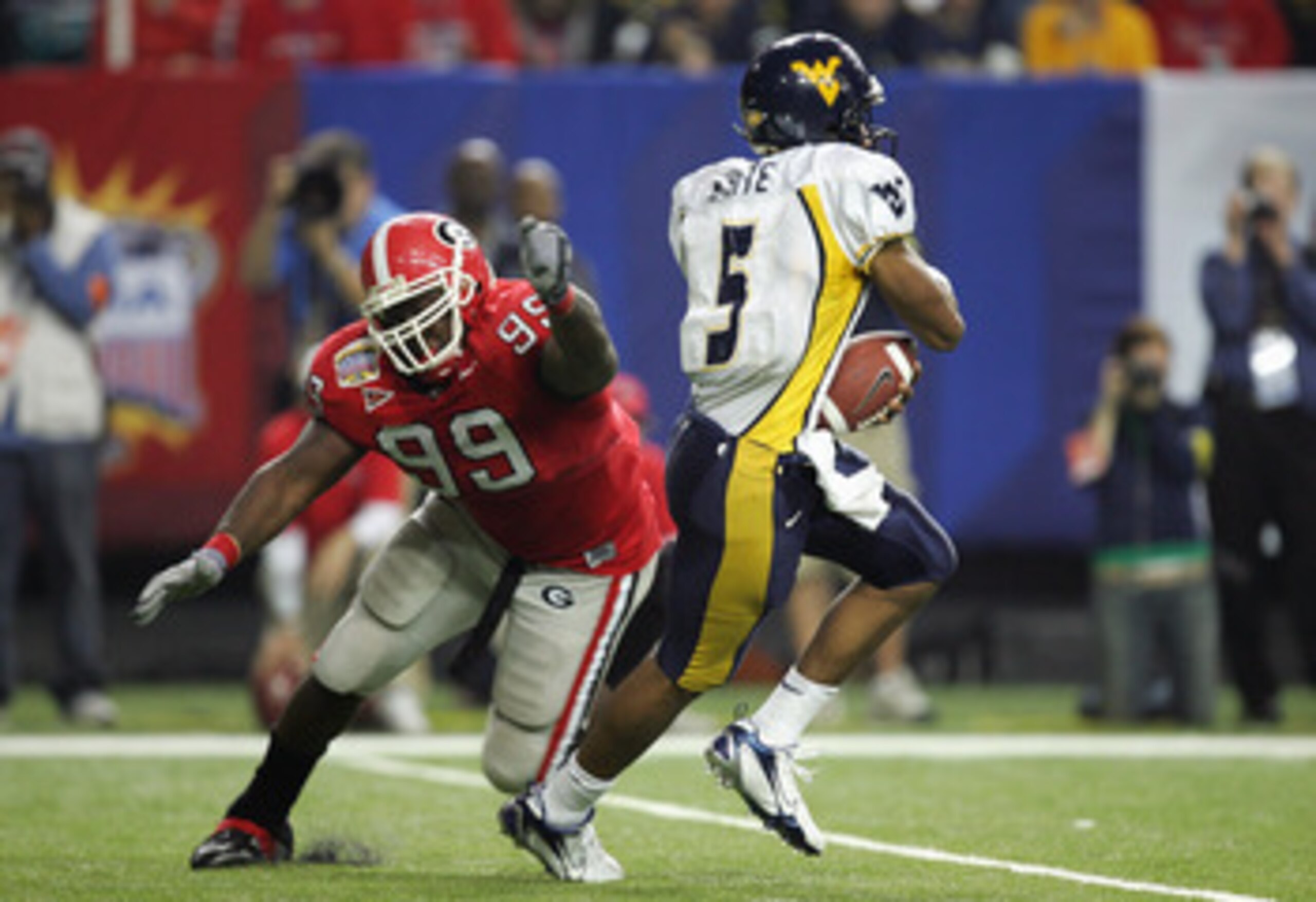 ATLANTA - JANUARY 2:  Pat White #5 of the West Virginia Mountaineers runs the ball as Charles Johnson #99 of the Georgia Bulldogs misses the tackle during the Nokia Sugar Bowl game at the Georgia Dome on January 2, 2006 in Atlanta, Georgia. The West Virgi
