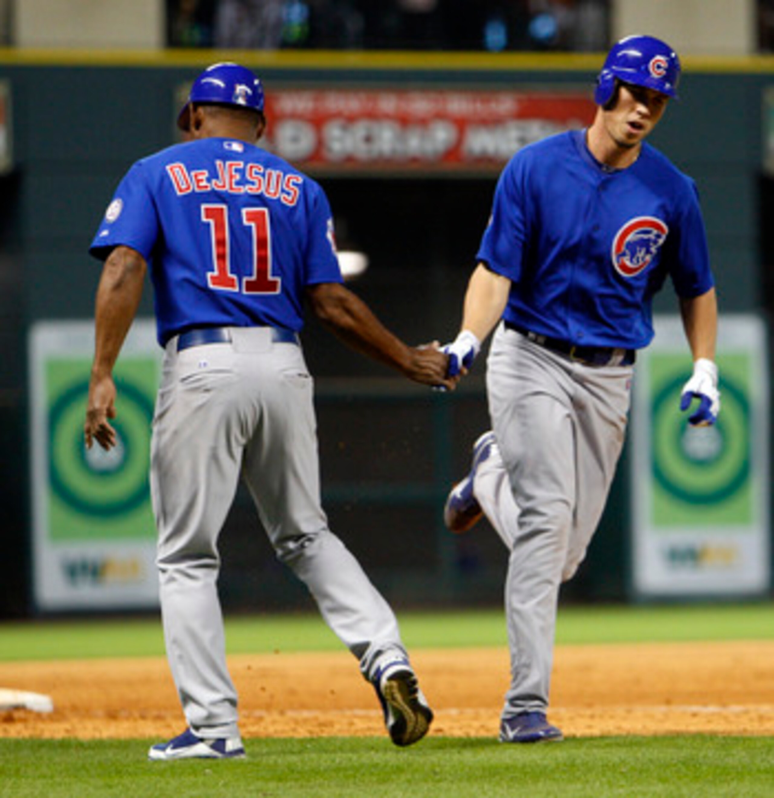 HOUSTON - APRIL 12:  Tyler Colvin #21 of the Chicago Cubs receives congratulations from third base coach  Ivan De Jesus after hitting a home run in the seventh inning against the Houston Astros at Minute Maid Park on April 12, 2011 in Houston, Texas.  (Ph