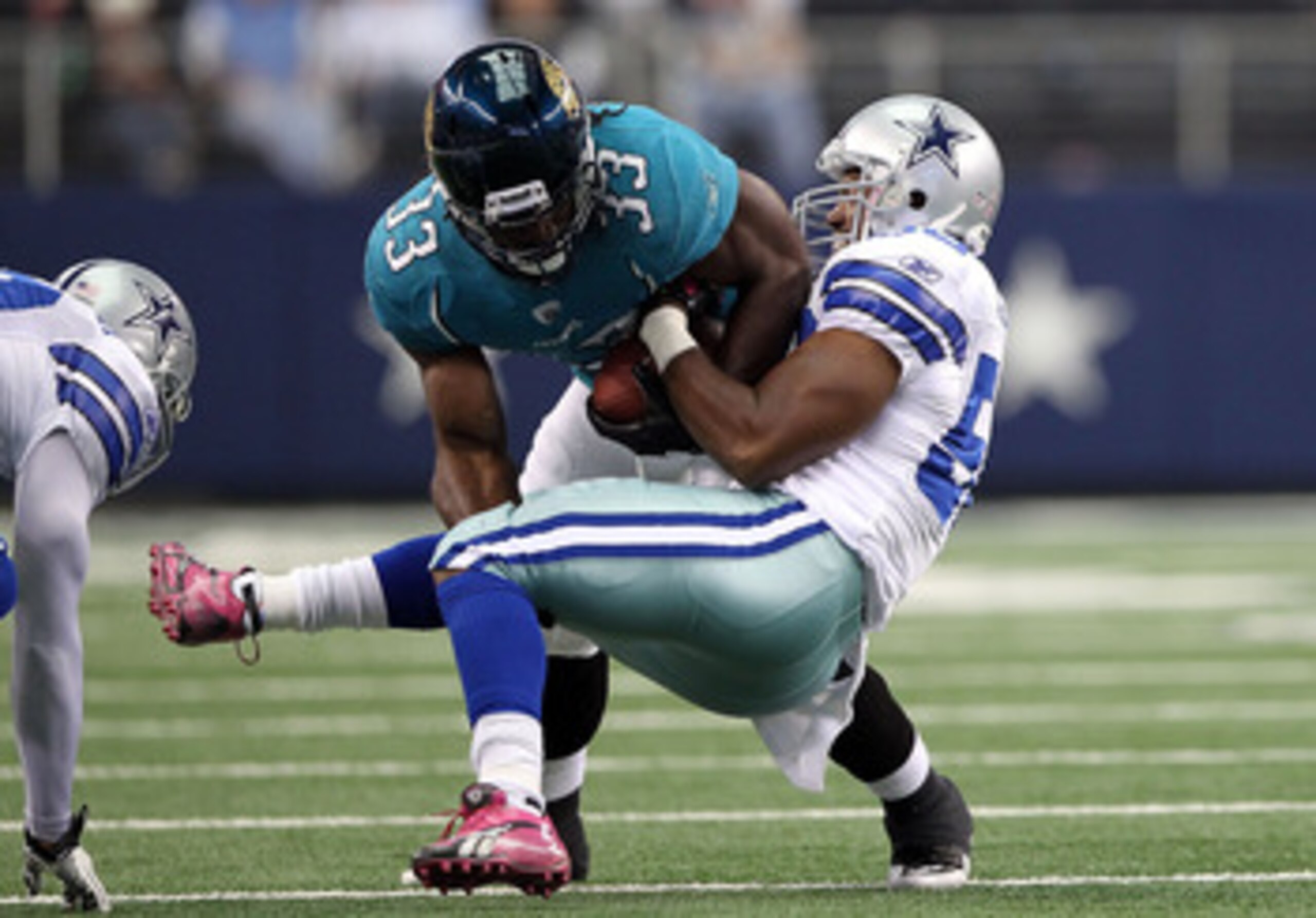 ARLINGTON, TX - OCTOBER 31:  Running back Greg Jones #33 of the Jacksonville Jaguars runs the ball against Bradie James #56 of the Dallas Cowboys at Cowboys Stadium on October 31, 2010 in Arlington, Texas.  (Photo by Chris Chambers/Getty Images)
