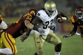 LOS ANGELES, CA - NOVEMBER 27:  Running back Robert Hughes #33 of the Notre Dame Fighting Irish carries the ball against linebacker Chris Galippo #54 of the USC Trojans at the Los Angeles Memorial Coliseum on November 27, 2010 in Los Angeles, California. 