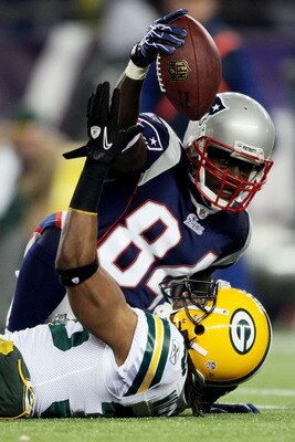 FOXBORO, MA - DECEMBER 19:  Wide receiver Deion Branch #84 of the New England Patriots tries to hold onto the ball during the fourth quarter of the game against the Green Bay Packers at Gillette Stadium on December 19, 2010 in Foxboro, Massachusetts.  (Ph