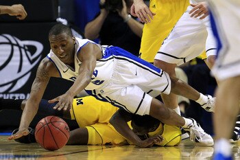 CHARLOTTE, NC - MARCH 20:  Nolan Smith #2 of the Duke Blue Devils dives for the ball over Tim Hardaway Jr. #10 of the Michigan Wolverines in the first half during the third round of the 2011 NCAA men's basketball tournament at Time Warner Cable Arena on M