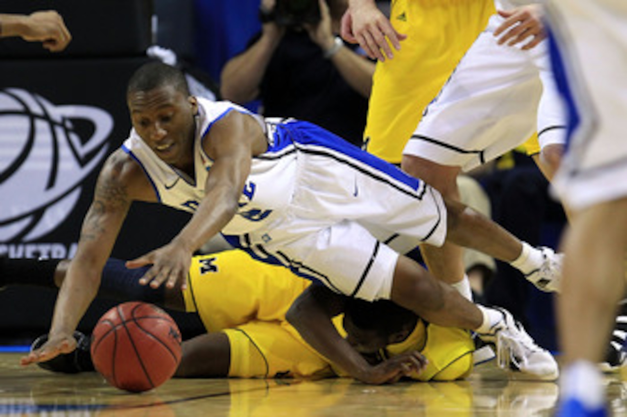 CHARLOTTE, NC - MARCH 20: Nolan Smith #2 of the Duke Blue Devils dives for the ball over Tim Hardaway Jr. #10 of the Michigan Wolverines in the first half during the third round of the 2011 NCAA men's basketball tournament at Time Warner Cable Arena on M CHARLOTTE, NC - MARCH 20: Nolan Smith #2 of the Duke Blue Devils dives for the ball over Tim Hardaway Jr. #10 of the Michigan Wolverines in the first half during the third round of the 2011 NCAA men's basketball tournament at Time Warner Cable Arena on M
