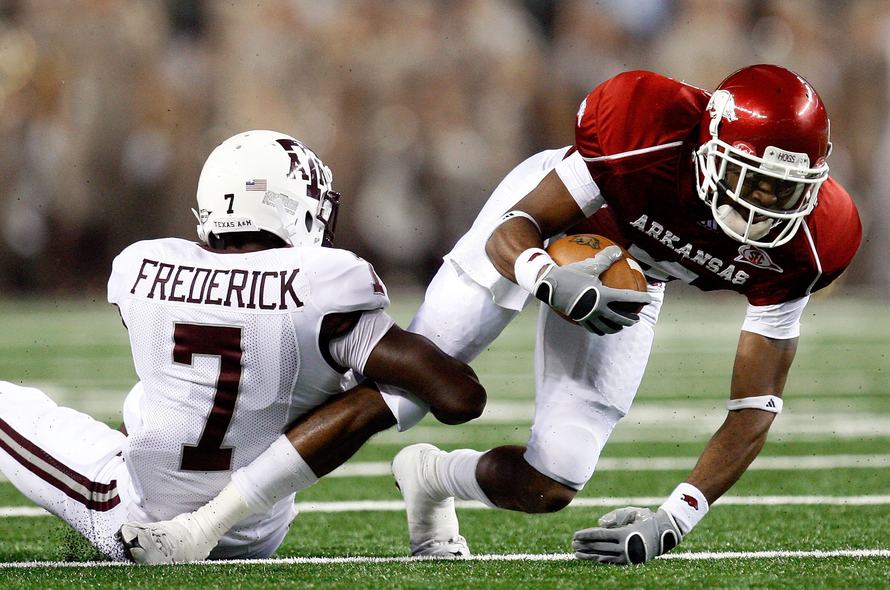 ARLINGTON, TX - OCTOBER 03:  Wide receiver Jarius Wright #4 of the Arkansas Razorbacks is tackled by Terrence Frederick #7 of the Texas A&M Aggies at Dallas Cowboys Stadium on October 3, 2009 in Arlington, Texas.  (Photo by Ronald Martinez/Getty Images)
