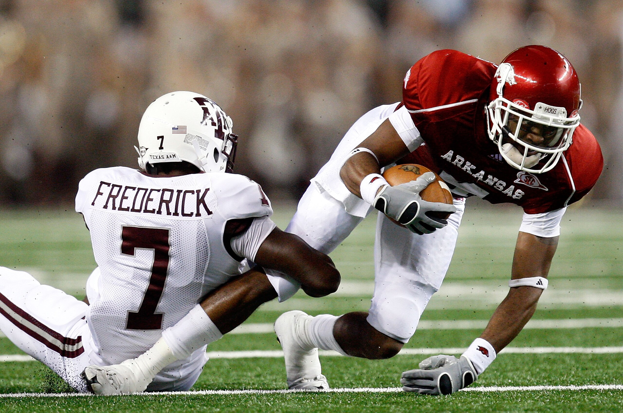ARLINGTON, TX - OCTOBER 03:  Wide receiver Jarius Wright #4 of the Arkansas Razorbacks is tackled by Terrence Frederick #7 of the Texas A&M Aggies at Dallas Cowboys Stadium on October 3, 2009 in Arlington, Texas.  (Photo by Ronald Martinez/Getty Images)
