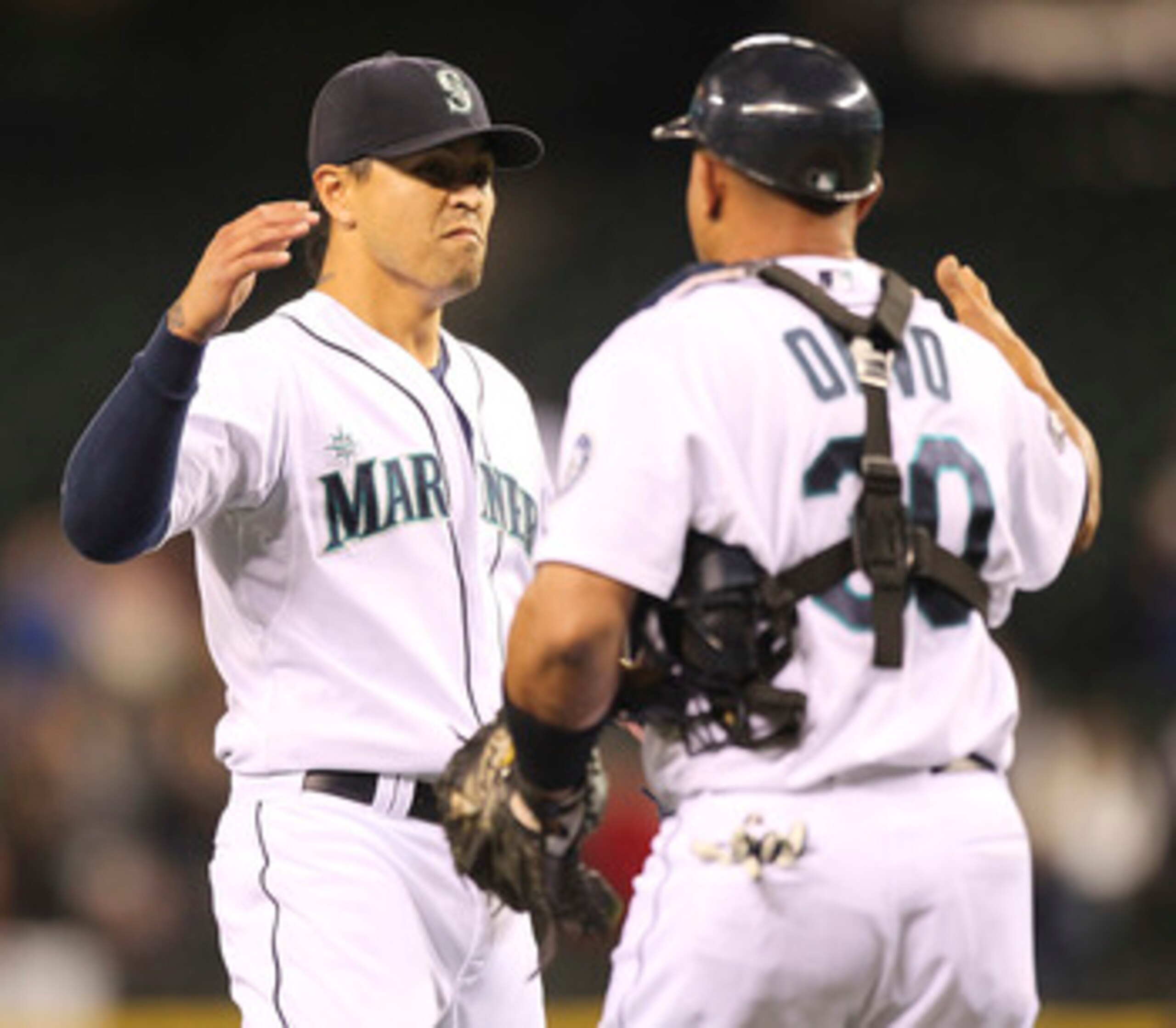 SEATTLE - JUNE 15:  Closing pitcher Brandon League #43 of the Seattle Mariners celebrates with catcher Miguel Olivo #30 after defeating the Los Angeles Angels of Anaheim 3-1 at Safeco Field on June 15, 2011 in Seattle, Washington. (Photo by Otto Greule Jr