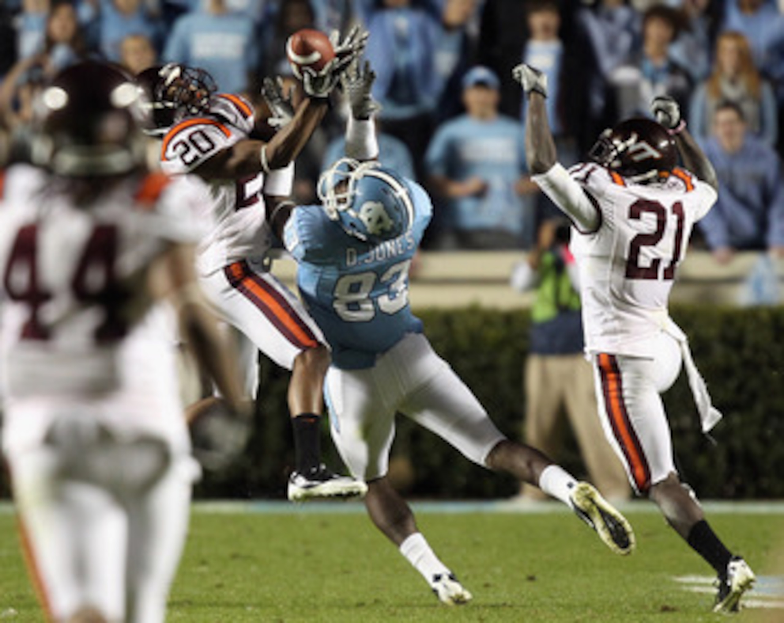 CHAPEL HILL, NC - NOVEMBER 13:  Jayron Hosley #20 of the Virginia Tech Hokies makes an interception as teammate Rashad Carmichael #21 watches on with Dwight Jones #83 of the North Carolina Tar Heels during their game at Kenan Stadium on November 13, 2010
