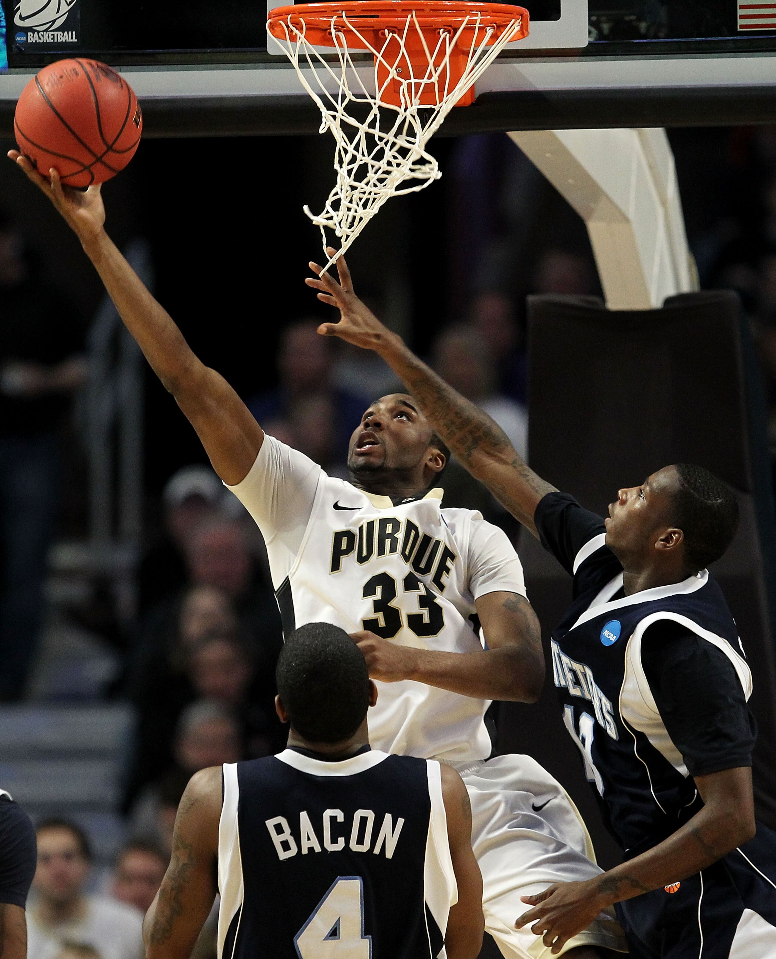 CHICAGO, IL - MARCH 18:  E'Twaun Moore #33 of the Purdue Boilermakers shoots against Steven Samuels #13 and Ryan Bacon #4 of the St. Peter's Peacocks in the second half during the second round of the 2011 NCAA men's basketball tournament at the United Cen