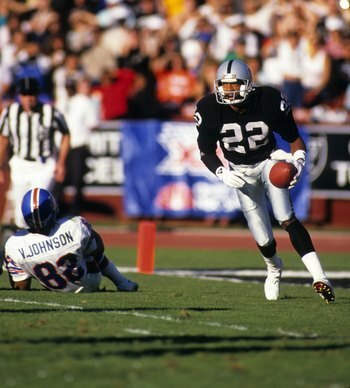 LOS ANGELES - DECEMBER 4:  Defensive back Mike Haynes #22 of the Los Angeles Raiders looks for room to run against the Denver Broncos wide receiver Vance Johnson #82 during a game at the Los Angeles Memorial Coliseum on December 4, 1988 in Los Angeles, Ca