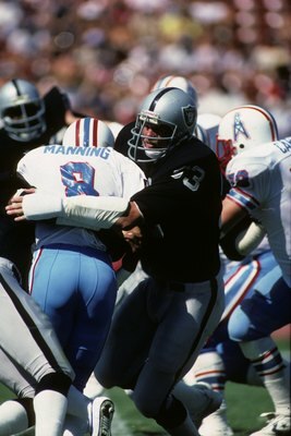 LOS ANGELES - SEPTEMBER 11:  Linebacker Ted Hendricks #83 of the Los Angeles Raiders tackles Houston Oilers quarterback Archie Manning #8 during the game at the Los Angeles Memorial Coliseum on September 11, 1983 in Los Angeles, California.  The Raiders w