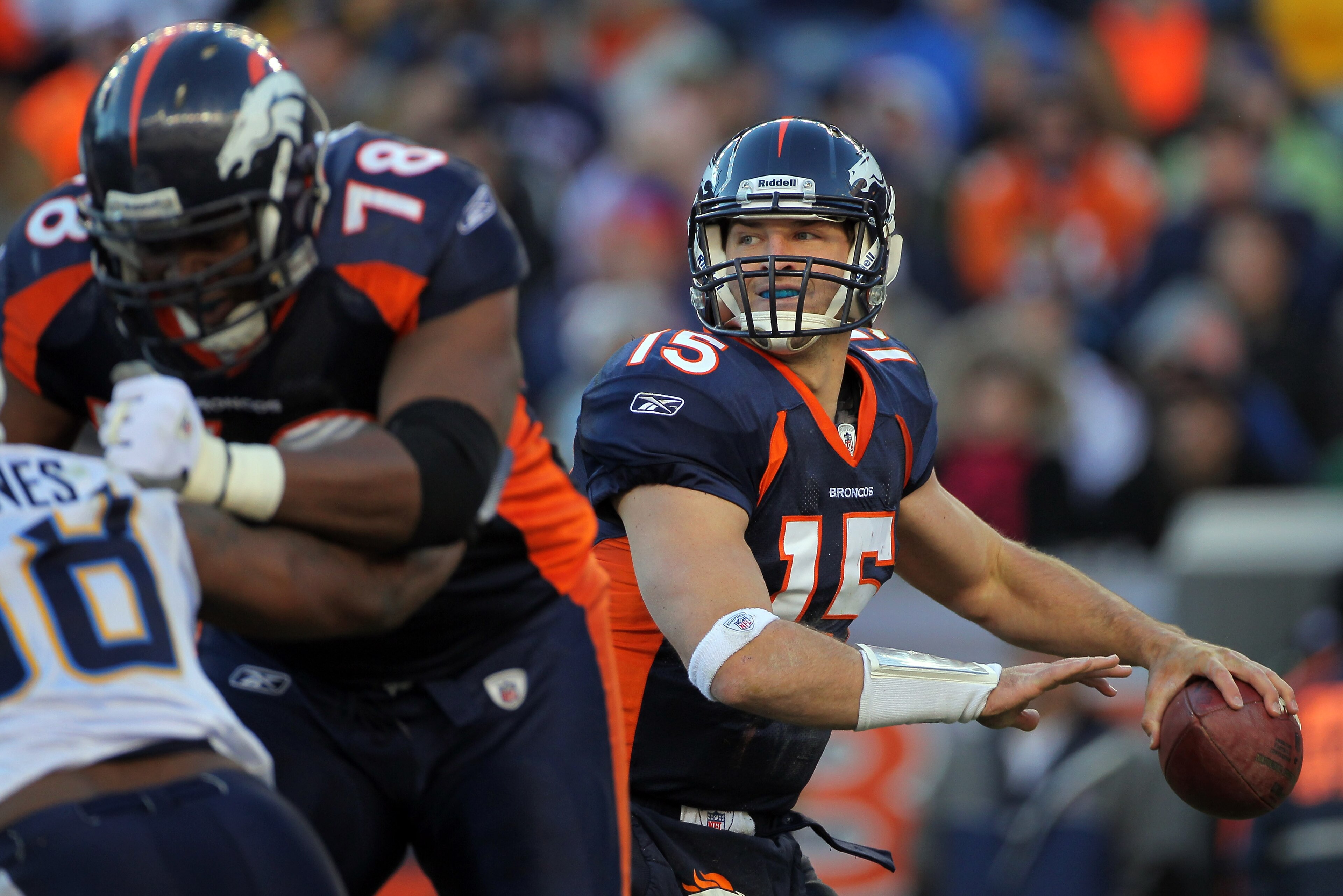DENVER - JANUARY 02:  Quarterback Tim Tebow #15 of the Denver Broncos looks to deliver a pass behind the protection of offensive lineman Ryan Clady #78 as he blocks Antwan Barnes #98 of the San Diego Chargers at INVESCO Field at Mile High on January 2, 20