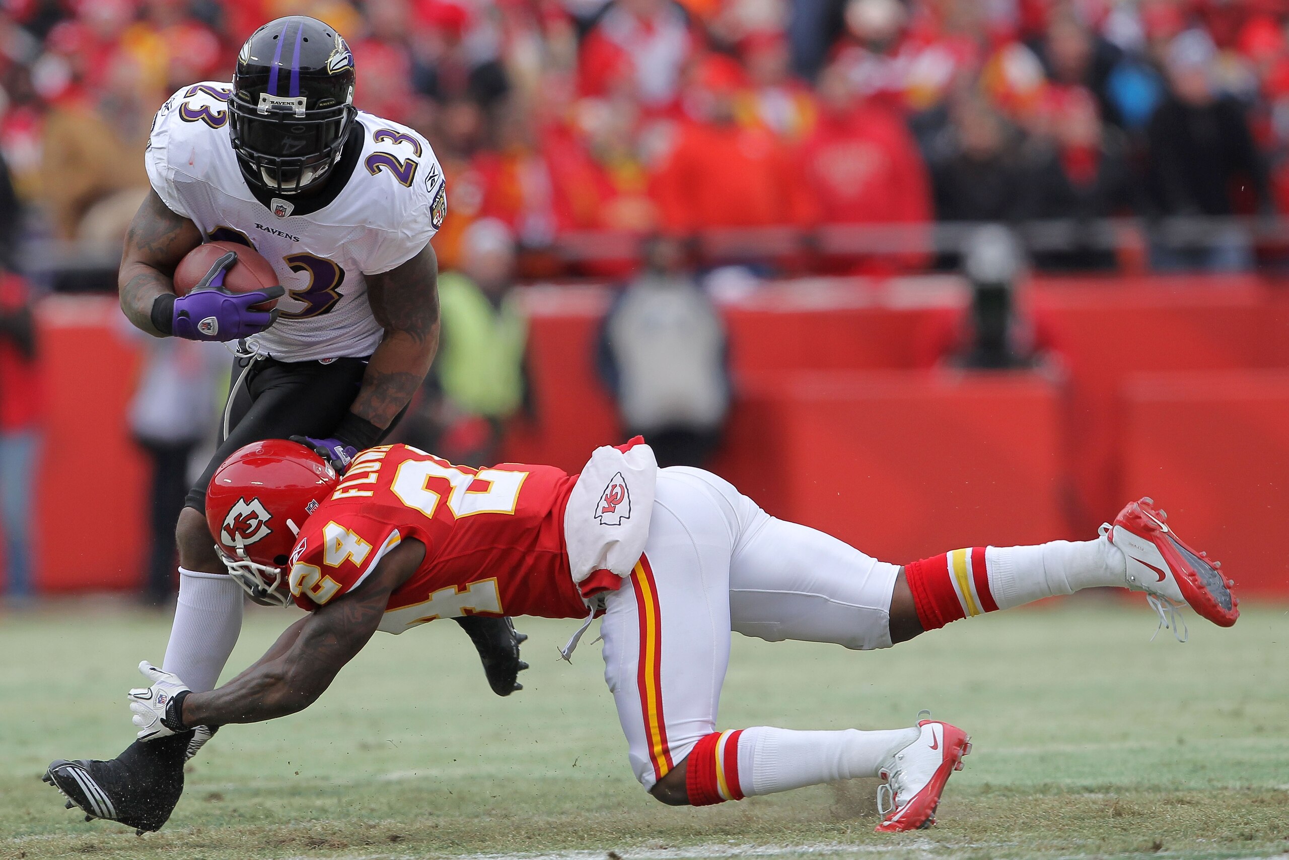 KANSAS CITY, MO - JANUARY 09:  Running back Willis McGahee #23 of the Baltimore Ravens breaks a tackle by cornerback Brandon Flowers #24 of the Kansas City Chiefs in the first half of their 2011 AFC wild card playoff game at Arrowhead Stadium on January 9