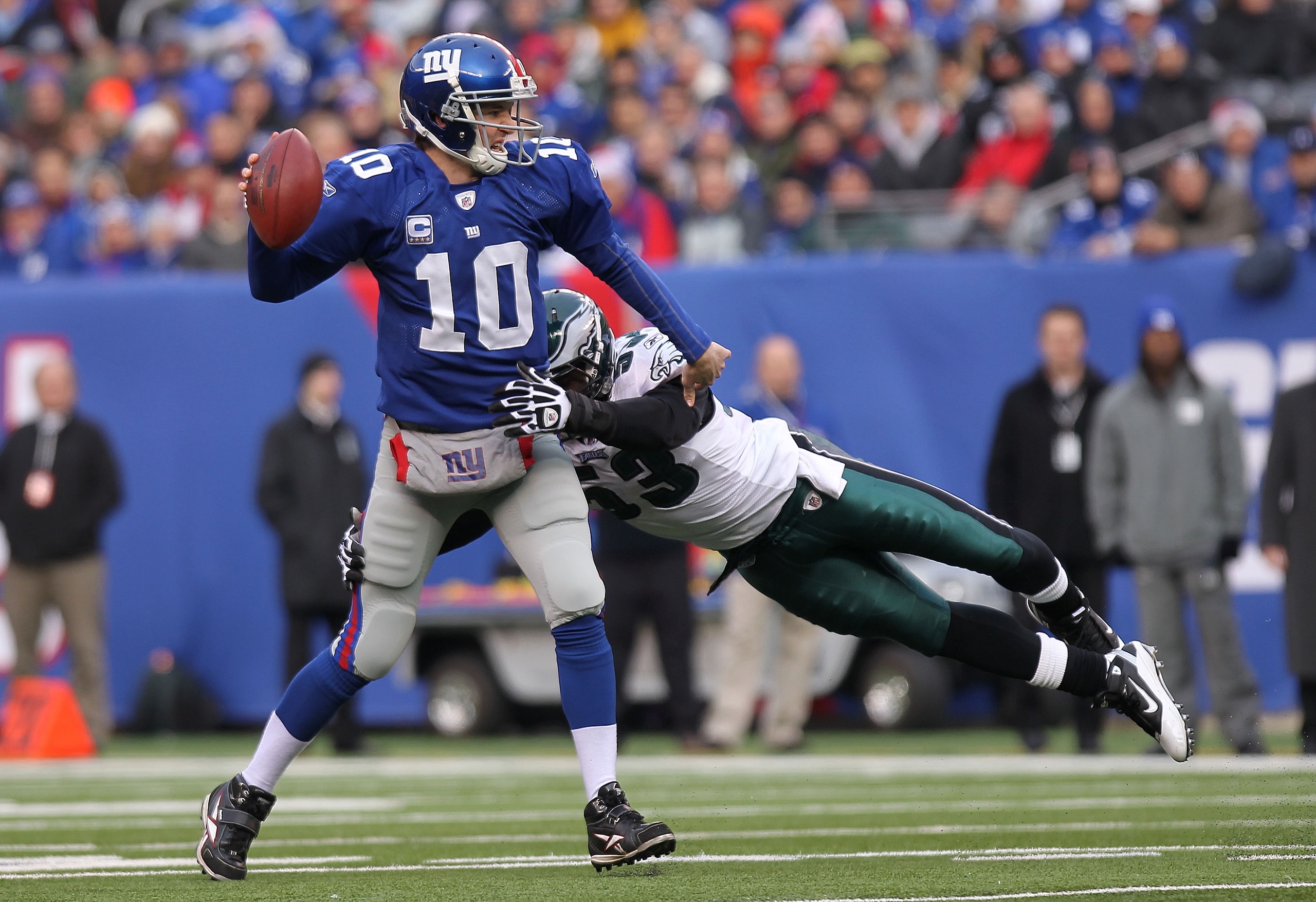 EAST RUTHERFORD, NJ - DECEMBER 19:  Eli Manning #10 of the New York Giants is sacked by Moise Fokou #53 of the Philadelphia Eagles at New Meadowlands Stadium on December 19, 2010 in East Rutherford, New Jersey.  (Photo by Nick Laham/Getty Images)
