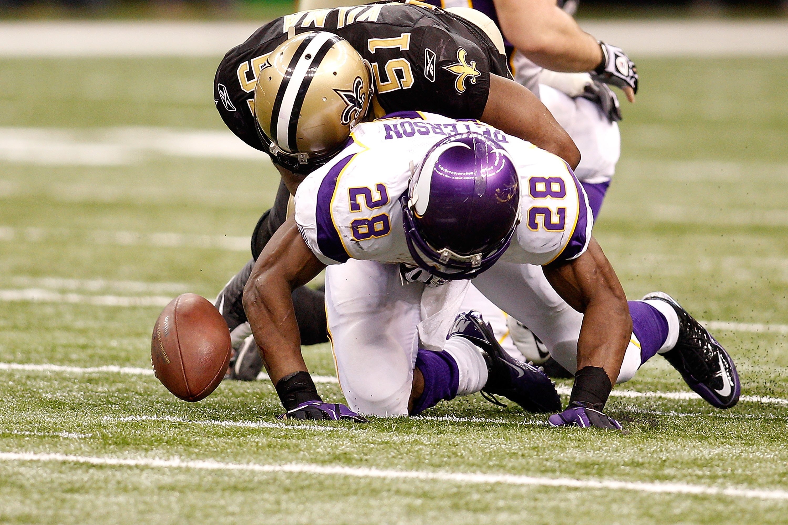NEW ORLEANS - JANUARY 24:  Adrian Peterson #28 of the Minnesota Vikings fumbles the ball as he was hit by Jonathan Vilma #51 of the New Orleans Saints during the NFC Championship Game at the Louisiana Superdome on January 24, 2010 in New Orleans, Louisian