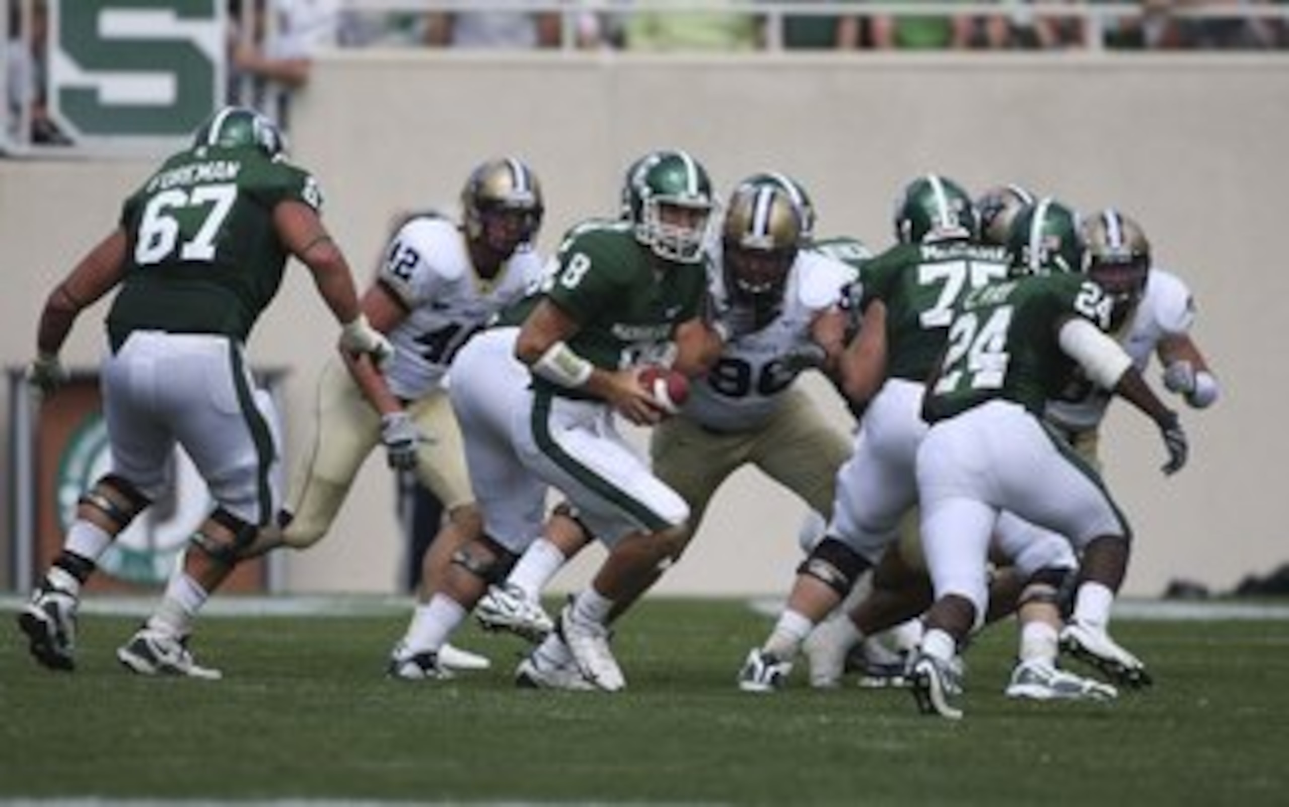 EAST LANSING, MI - SEPTEMBER 05: Quarterback Kirk Cousins #8 of the Michigan State Spartans hands the ball off to Running Back Caulton Ray #24 of the Michigan State Spartans during the game against the Montana State Bobcats on September 5, 2009 at Spartan