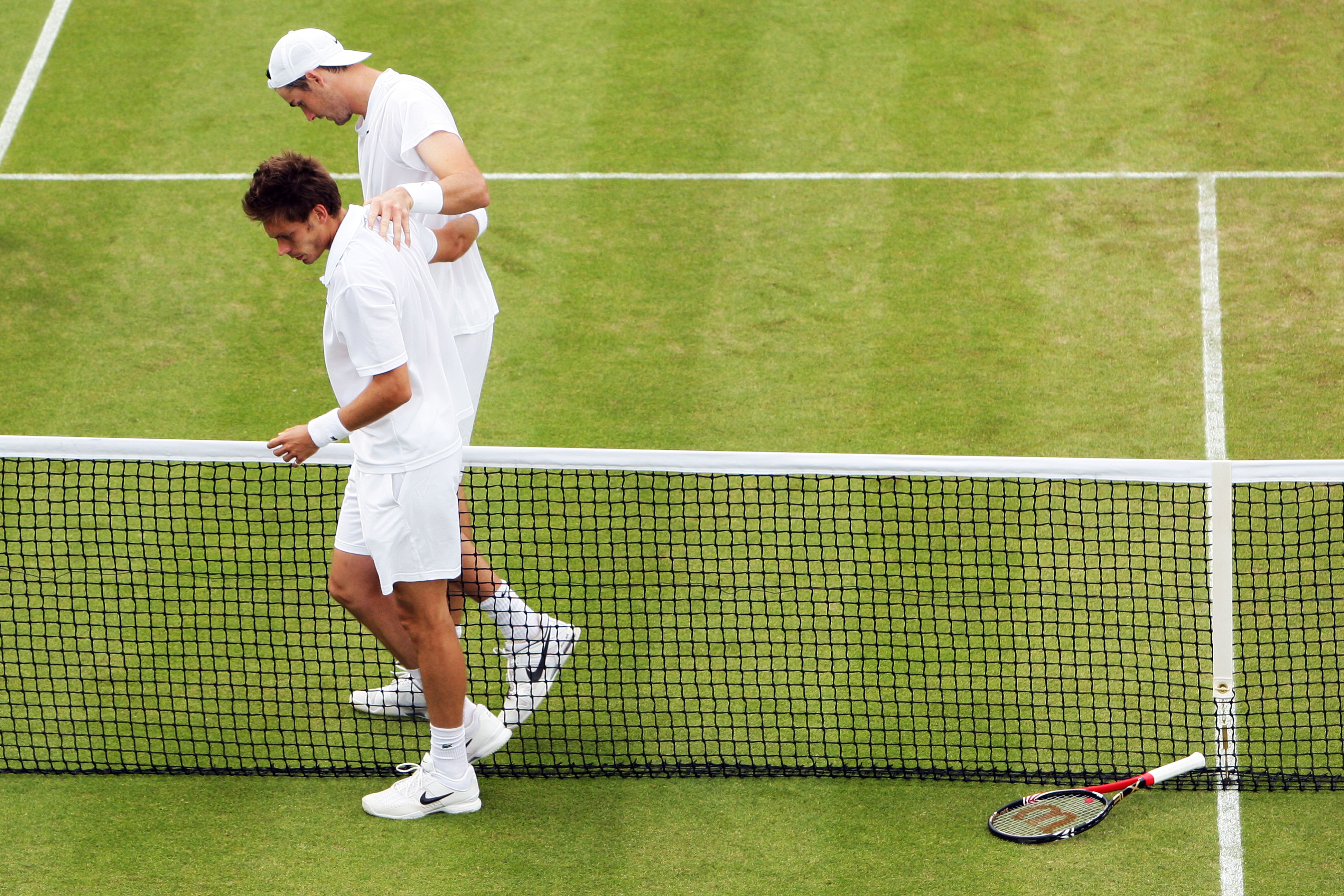 LONDON, ENGLAND - JUNE 24:  John Isner of USA (top) celebrates winning on the third day of his first round match against Nicolas Mahut of France on Day Four of the Wimbledon Lawn Tennis Championships at the All England Lawn Tennis and Croquet Club on June
