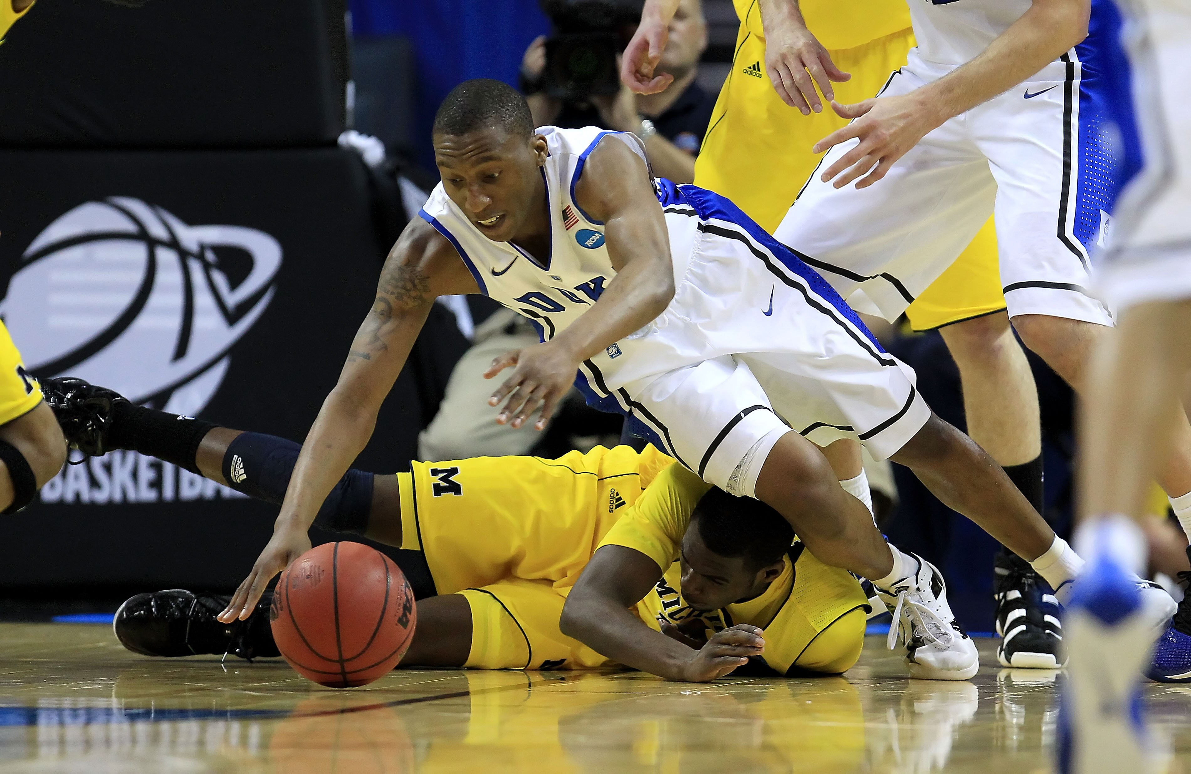 CHARLOTTE, NC - MARCH 20: Nolan Smith #2 of the Duke Blue Devils dives for the ball over Tim Hardaway Jr. #10 of the Michigan Wolverines in the first half during the third round of the 2011 NCAA men's basketball tournament at Time Warner Cable Arena on M CHARLOTTE, NC - MARCH 20: Nolan Smith #2 of the Duke Blue Devils dives for the ball over Tim Hardaway Jr. #10 of the Michigan Wolverines in the first half during the third round of the 2011 NCAA men's basketball tournament at Time Warner Cable Arena on M