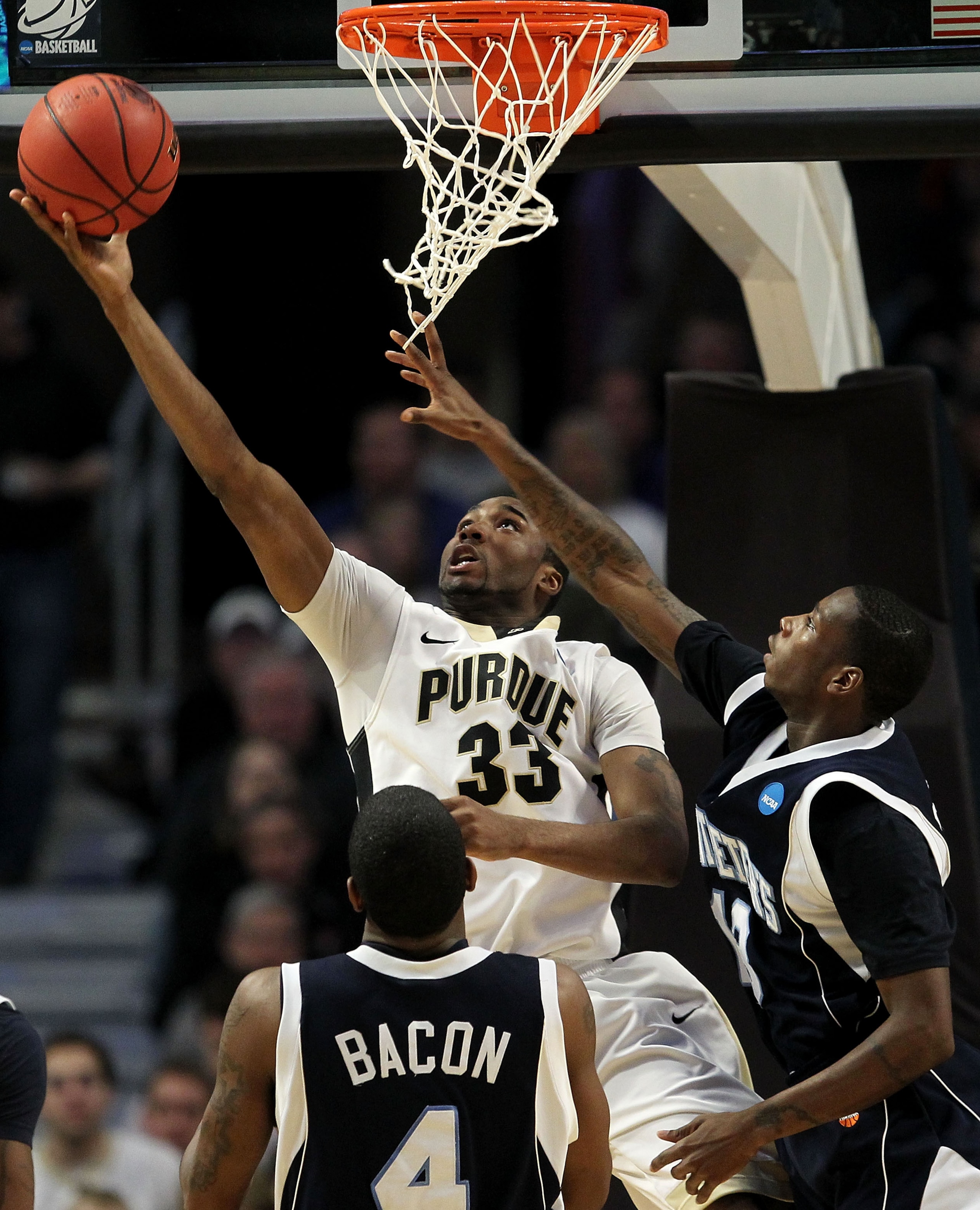 CHICAGO, IL - MARCH 18: E'Twaun Moore #33 of the Purdue Boilermakers shoots against Steven Samuels #13 and Ryan Bacon #4 of the St. Peter's Peacocks in the second half during the second round of the 2011 NCAA men's basketball tournament at the United Cen CHICAGO, IL - MARCH 18: E'Twaun Moore #33 of the Purdue Boilermakers shoots against Steven Samuels #13 and Ryan Bacon #4 of the St. Peter's Peacocks in the second half during the second round of the 2011 NCAA men's basketball tournament at the United Cen